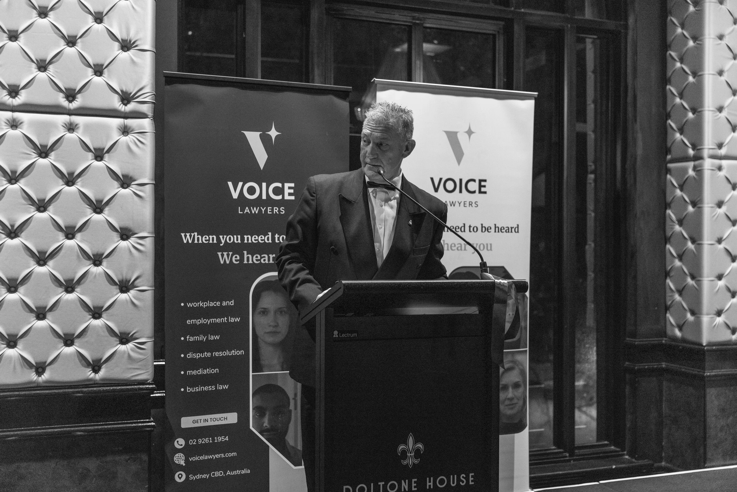 Speaker at podium during Voice Lawyers charity gala.