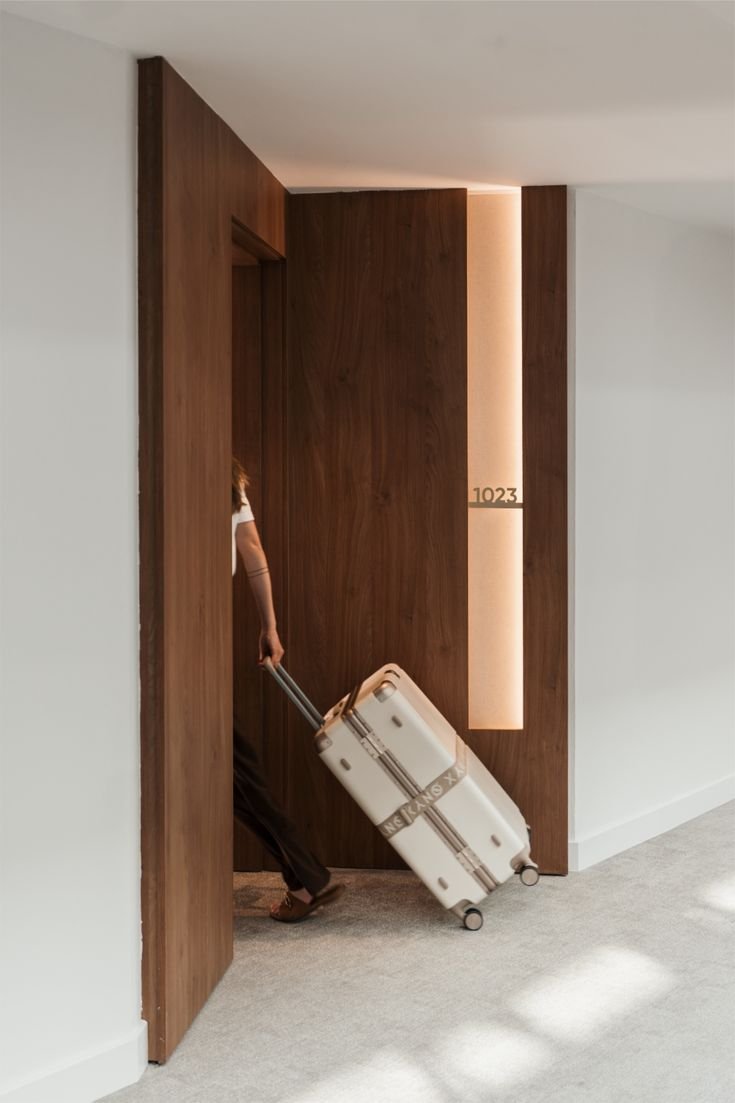 Person entering hotel room with lauggage