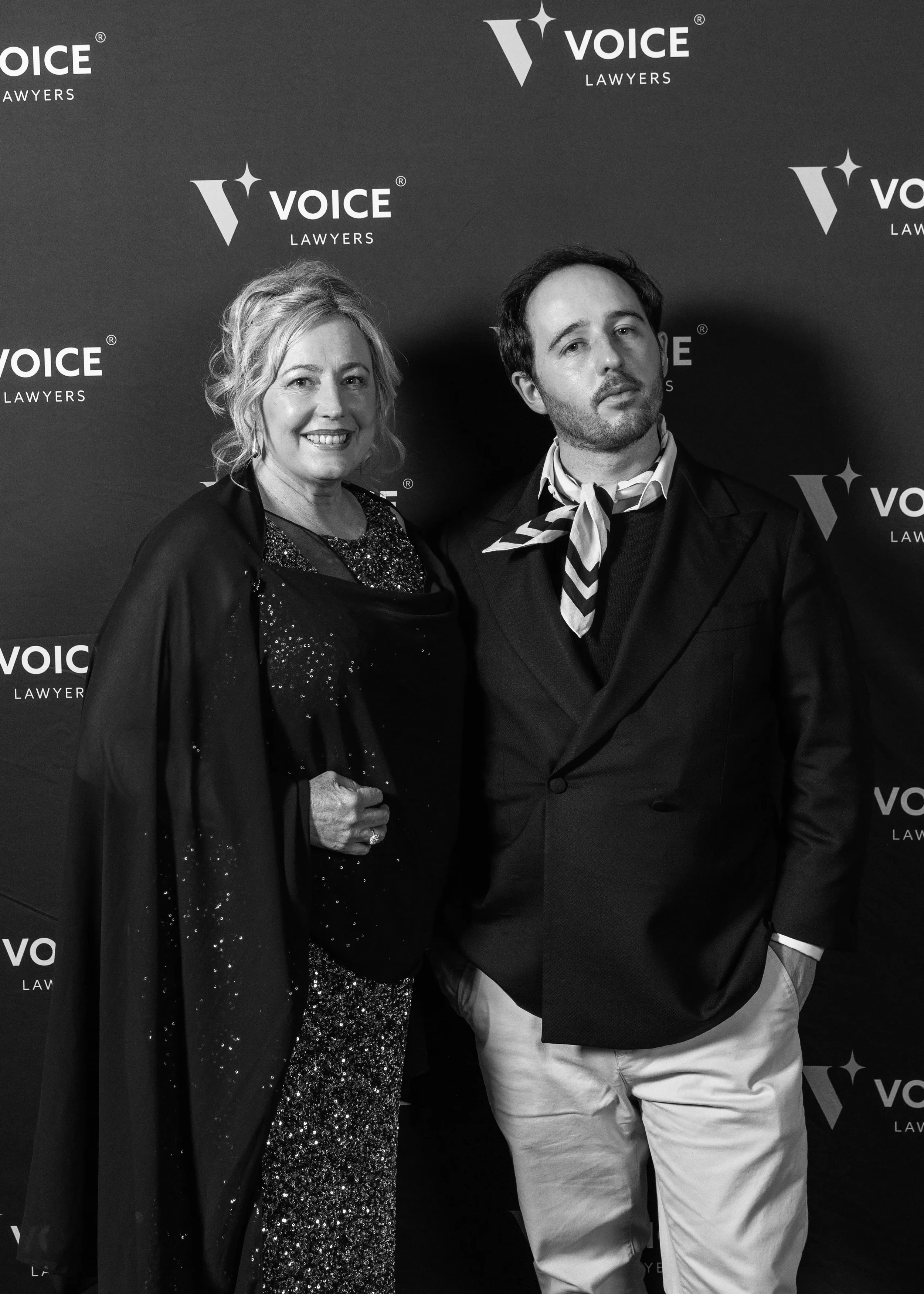 Jack and Kayte New posing in front of Voice Lawyers media wall.