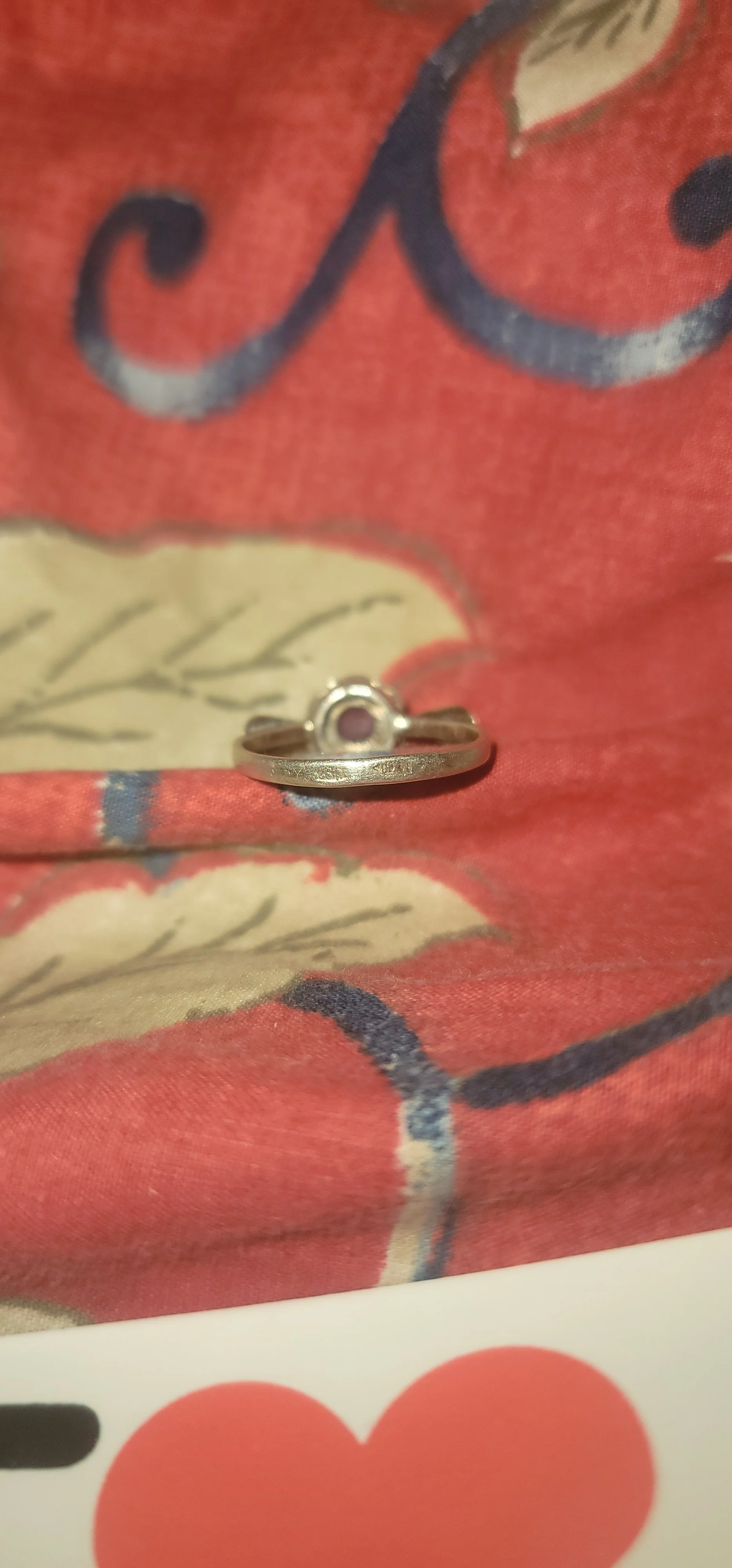 Underside of the ring showing the open-back bezel, the stone visible from behind