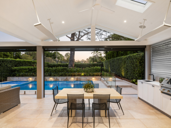Indoor patio with ceiling fan, skylights, and view of backyard pool and garden