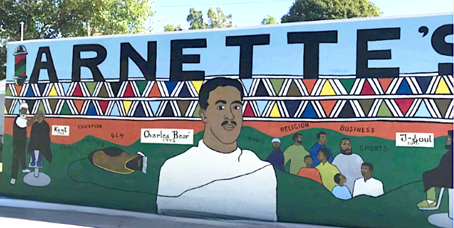 Carbondale, IL mural honoring Charles Bear, depicting people, cultural symbols, and themes like education, technology, religion, and business.