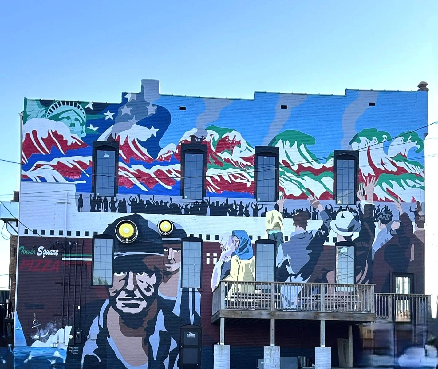 Mural in Southern Illinois nonprofit community arts mural project independent artists, Carbondale, IL Welcome to America with the Statue of Liberty and the words 'Tower Square Pizza'.