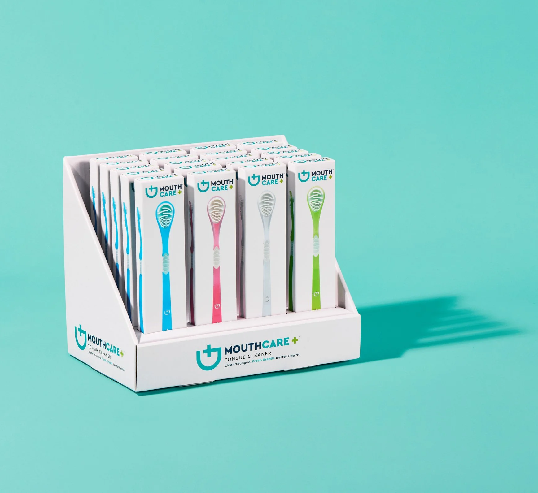 Display of mouth care toothbrushes in various colors in a white stand against a teal background.