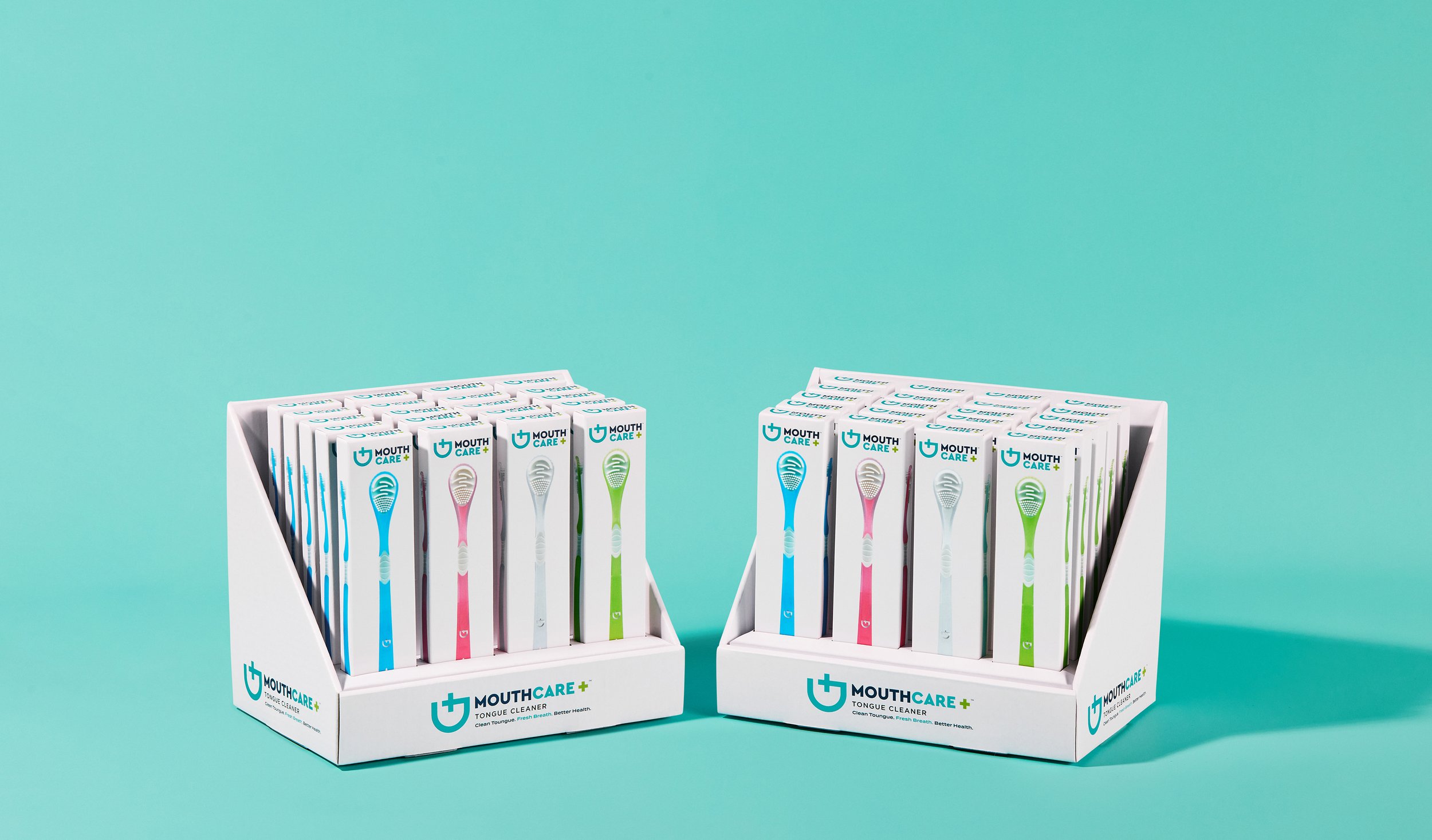Two white display boxes filled with colorful toothbrushes, set against a turquoise background.