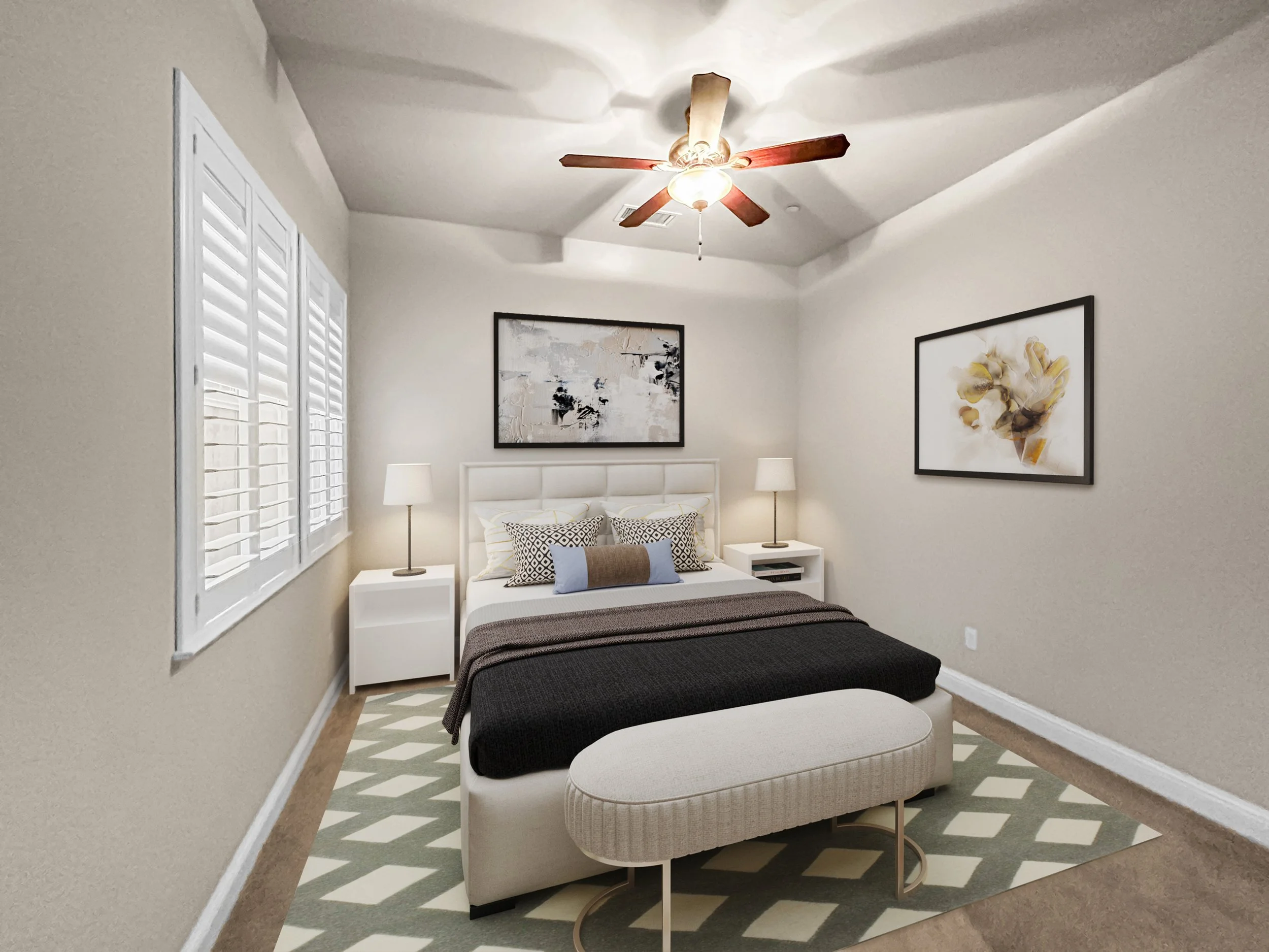 A bedroom with a white bed and a bench at the foot of the bed. The room has two nightstands with lamps, two framed artworks on the walls, a ceiling fan, a window with white blinds, and a patterned rug on the floor.