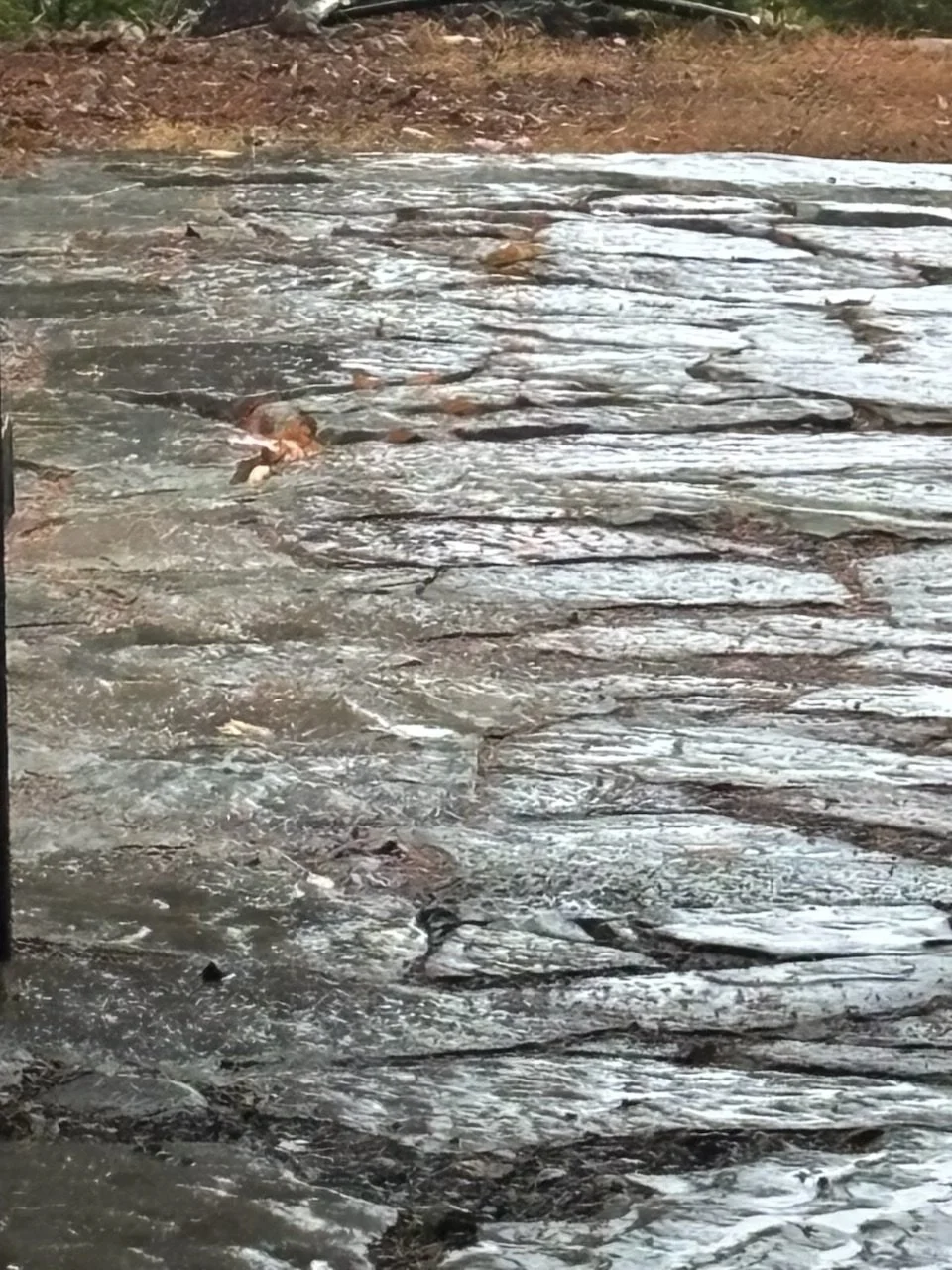 A Horizontal photo of a flagstone driveway, showing the flatness and imperfections of the stone driveway