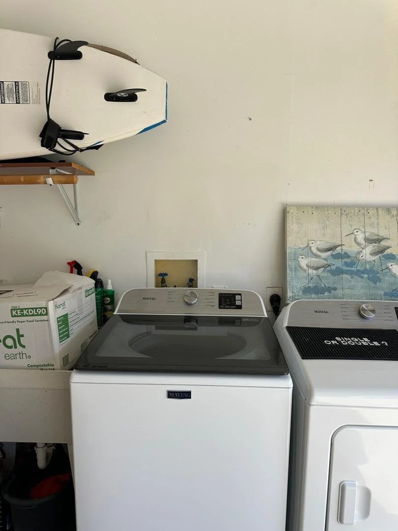 After drywall repair and wall restoration in a laundry area with a clean, smooth finish that fully encloses plumbing access and restores a neat, finished appearance.