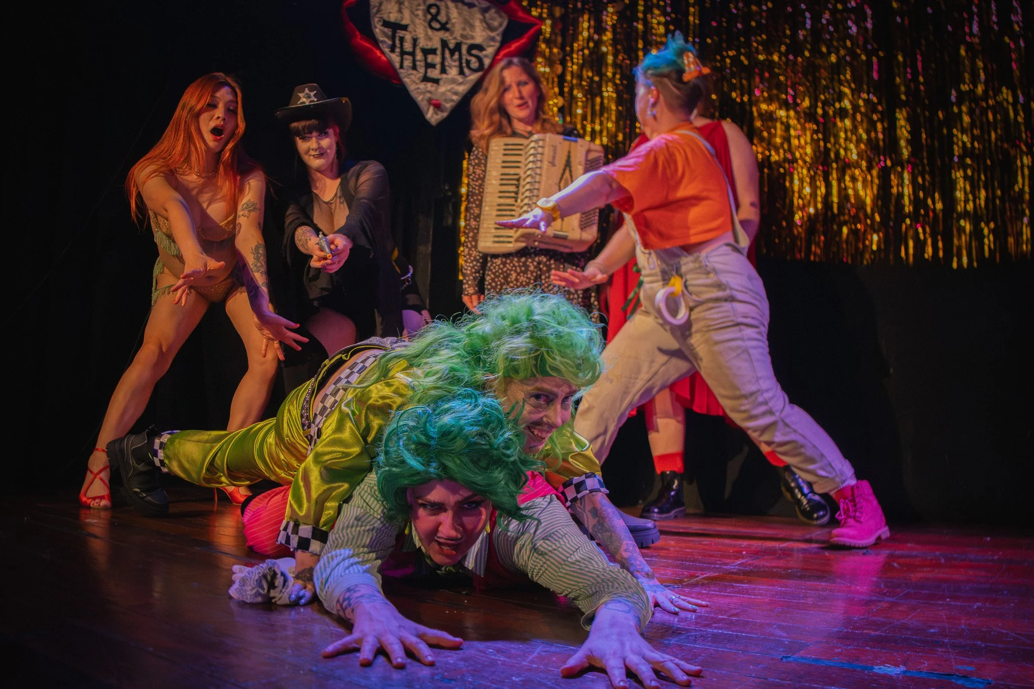 A group of Comic Variety show performers posing dramatically on a stage