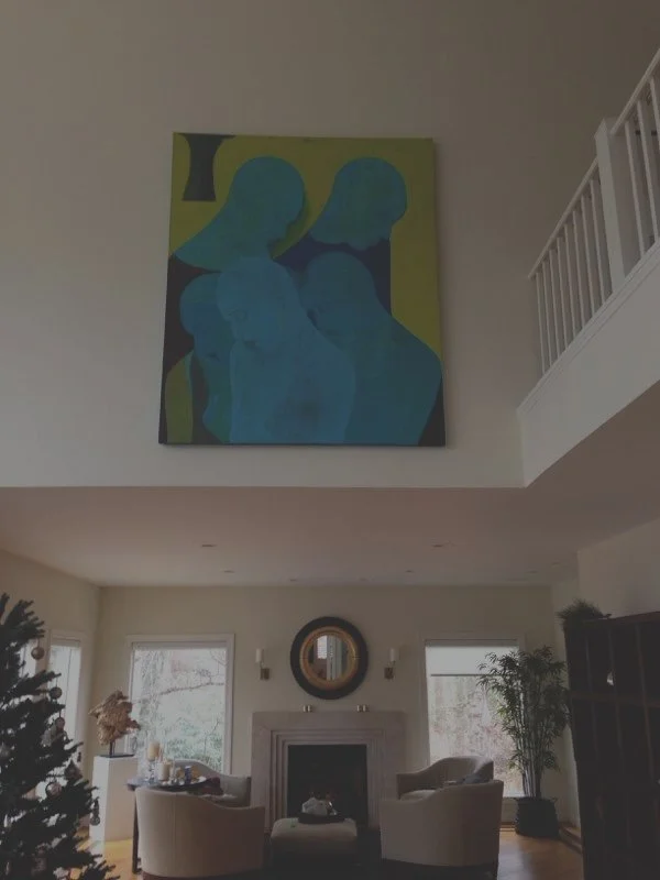 A large abstract painting of three blue human figures on a yellow background hanging above a living room fireplace.