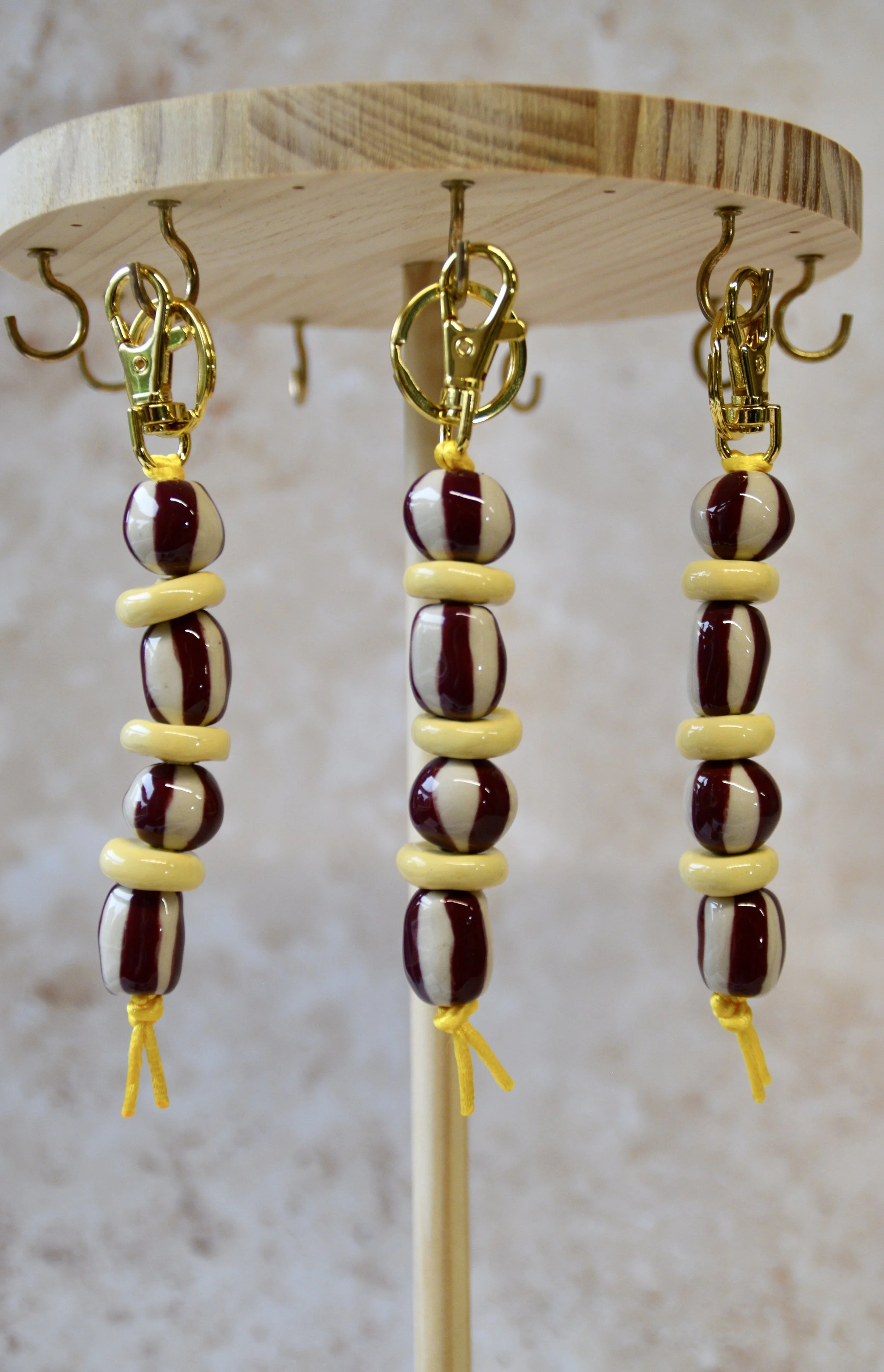 Burgundy and yellow ceramic bead bag charms