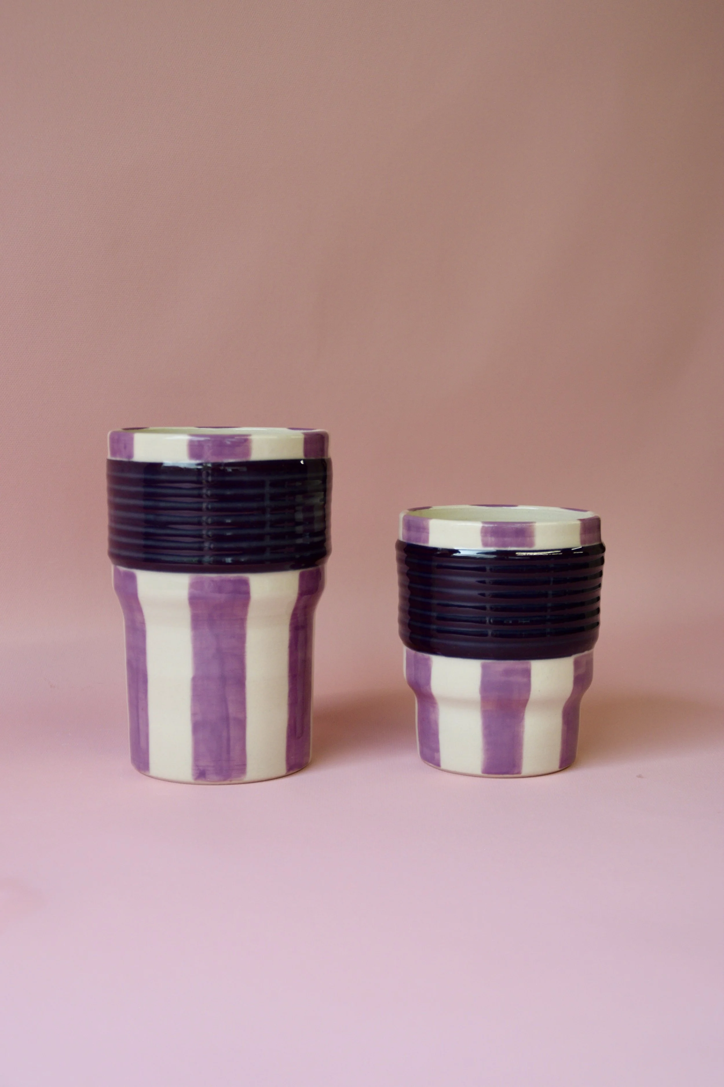 Large and small purple striped ceramic tumblers