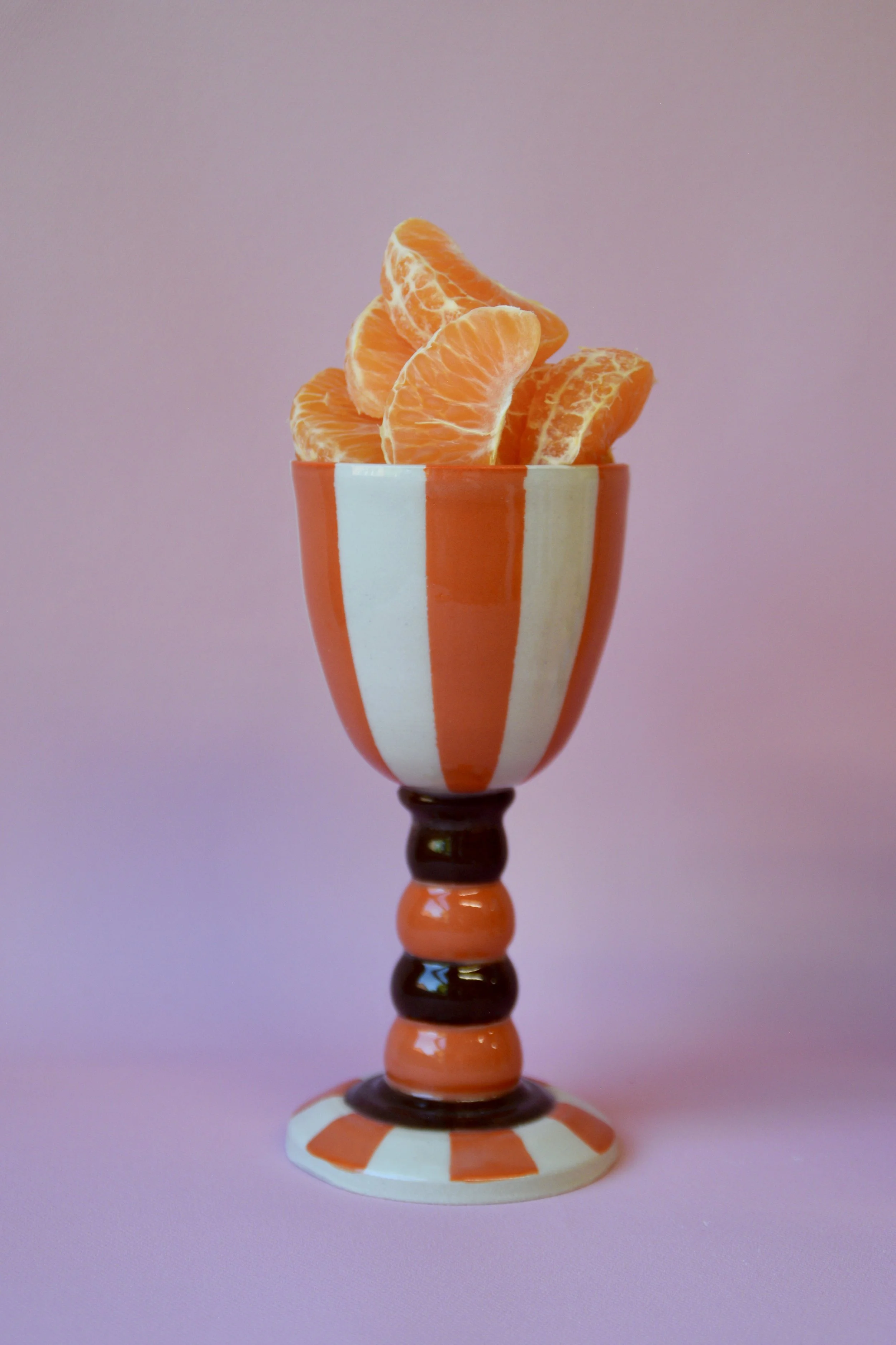 Orange striped ceramic goblet with clementines