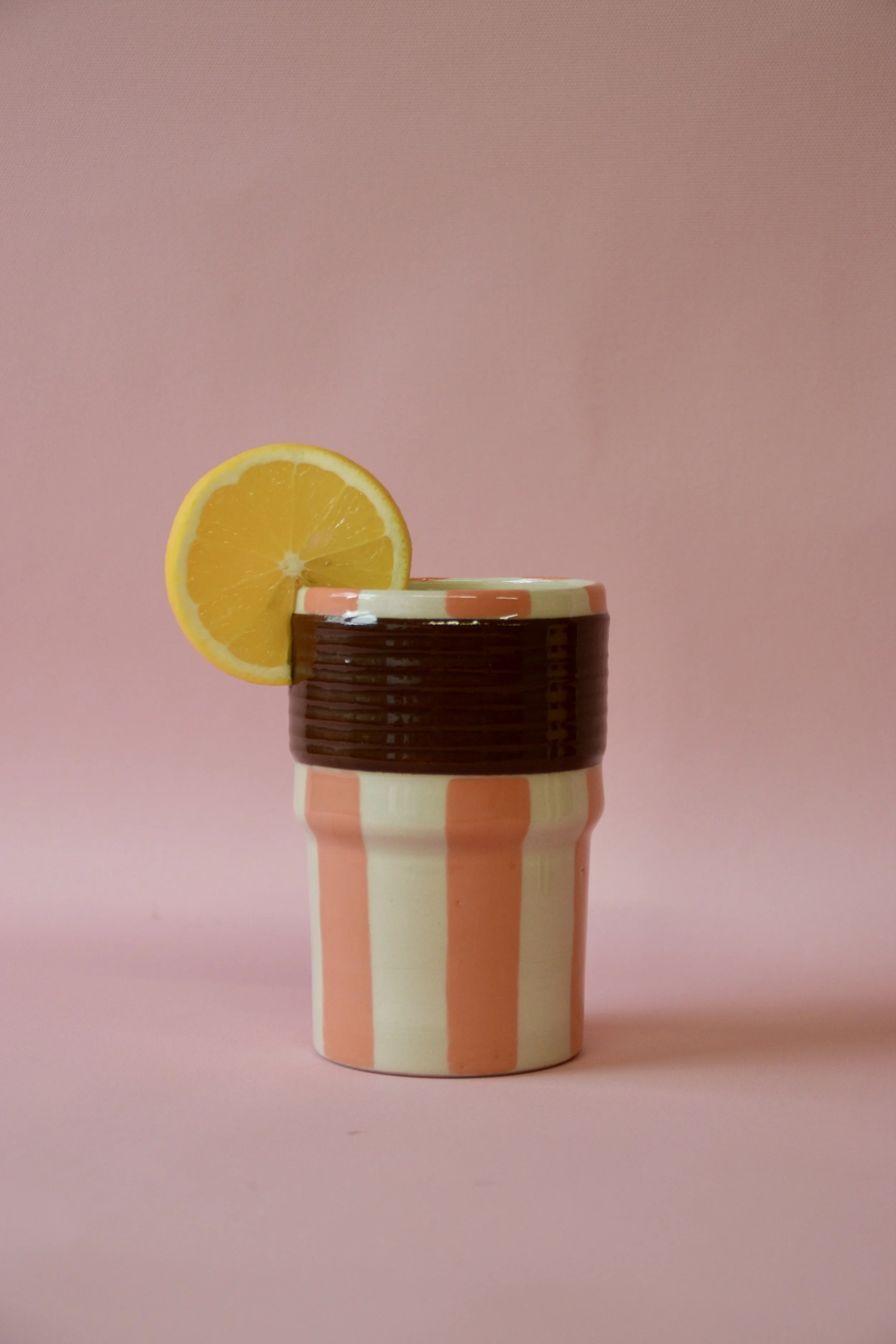 Orange and brown striped ceramic tumbler with orange