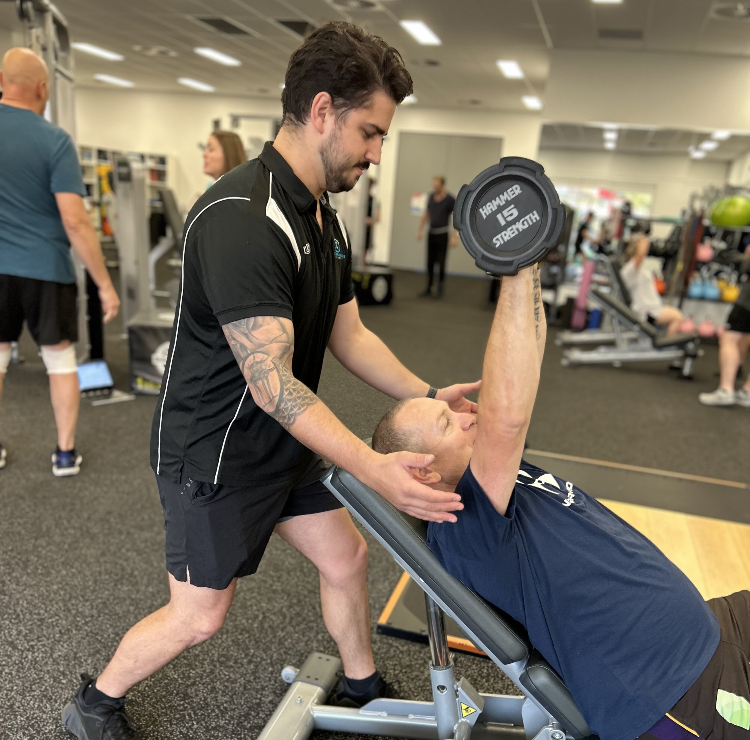 EP helping a client with incline bench press.