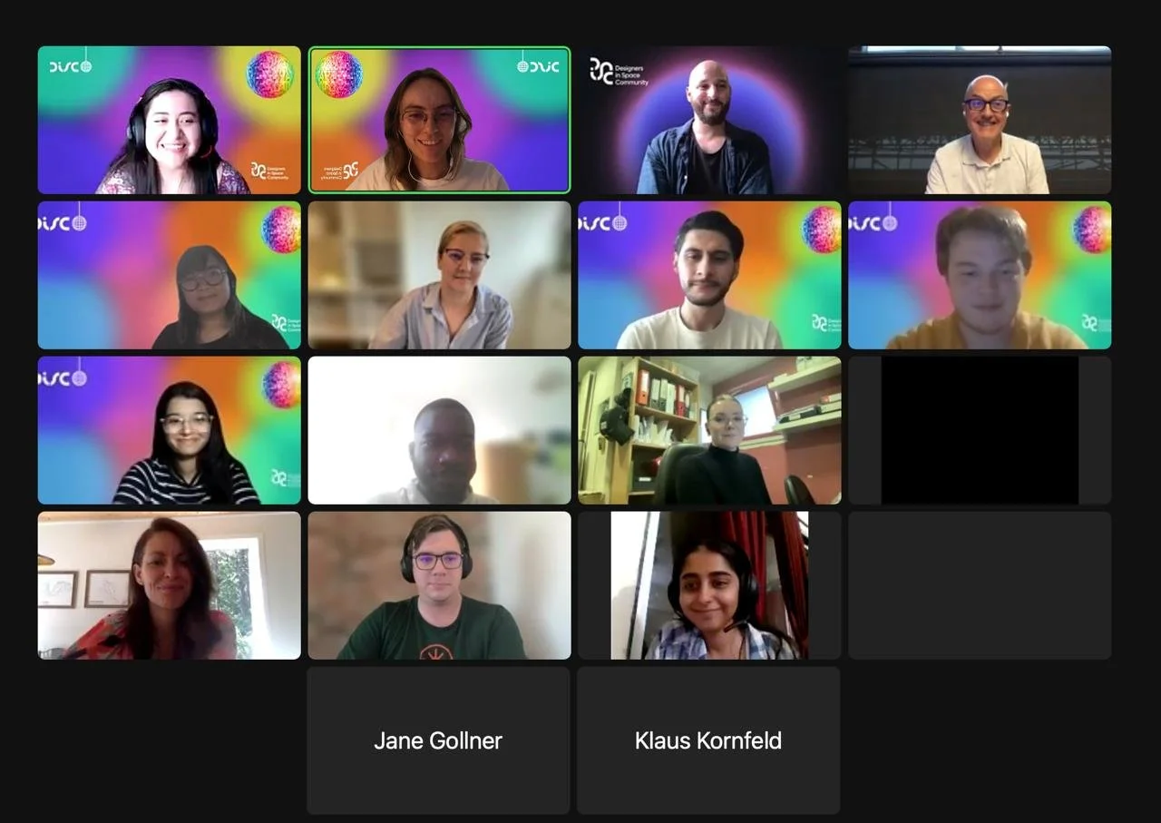Virtual meeting with fifteen participants, some with colorful virtual backgrounds, some in home offices or neutral spaces, engaged in a video conference.