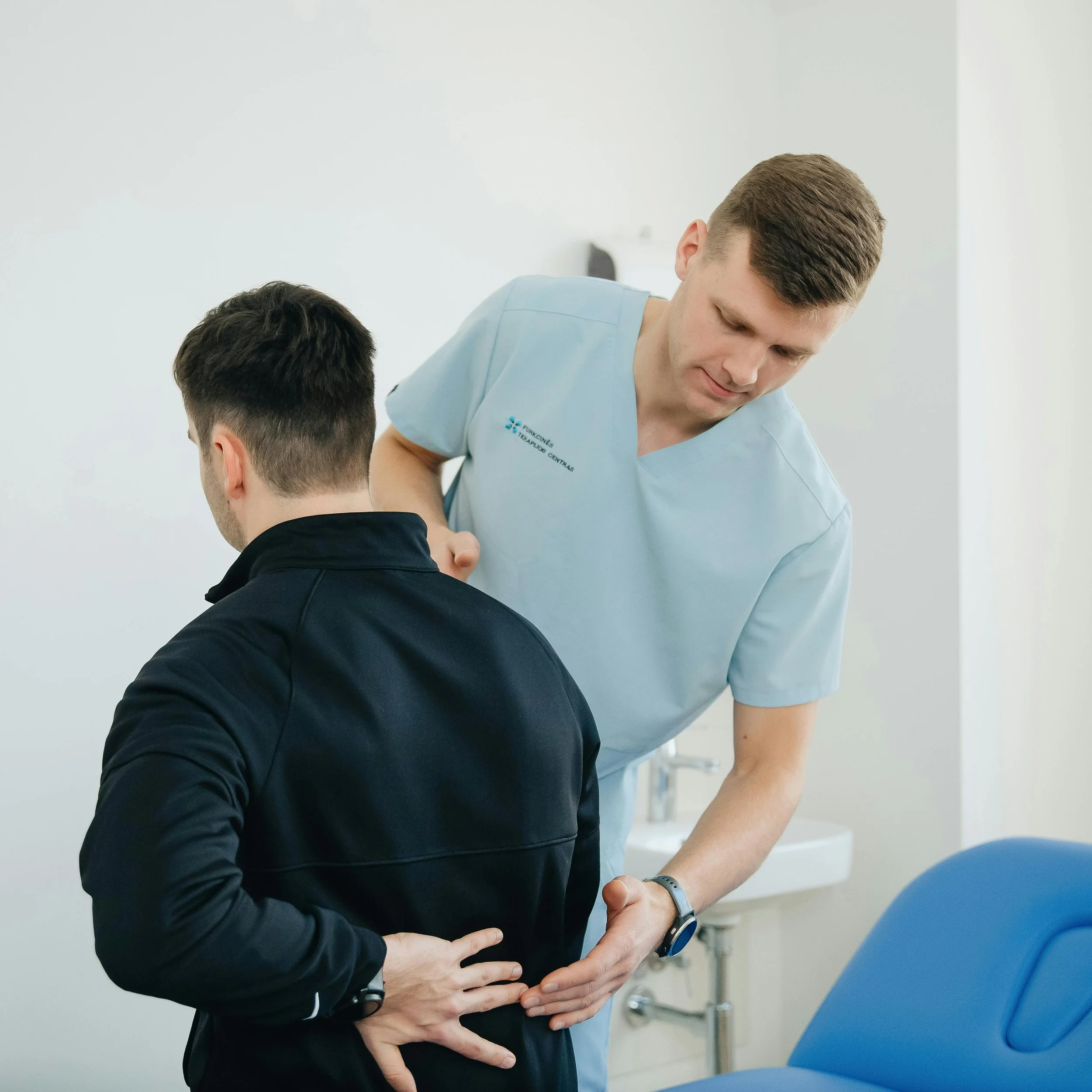 A healthcare professional attending to a patient in a medical setting, with a focus on the interaction and medical attire.