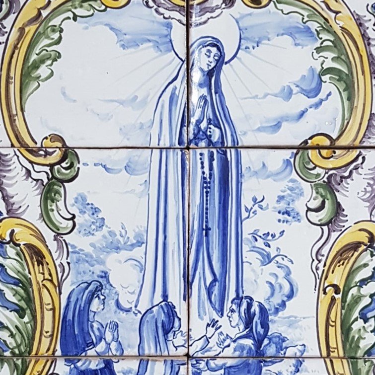 Religious tile artwork depicting the Virgin Mary with three children praying in front of her, surrounded by a decorative ornate border.