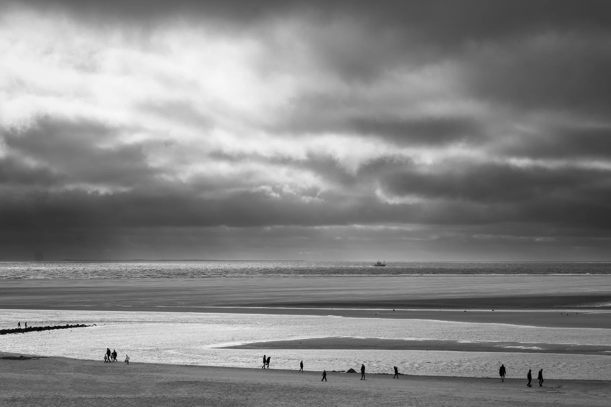 Strand mit Menschen, Blick aufs Meer, Wolken am Himmel, Schiffe in der Ferne