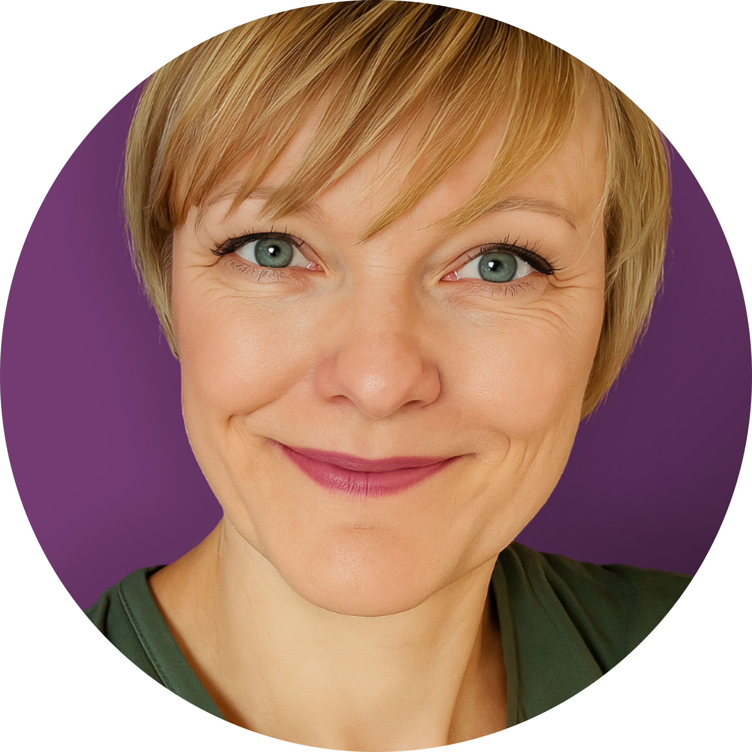 Close-up of a smiling woman with short blonde hair, blue eyes, and light skin, wearing a dark green top, against a purple background.