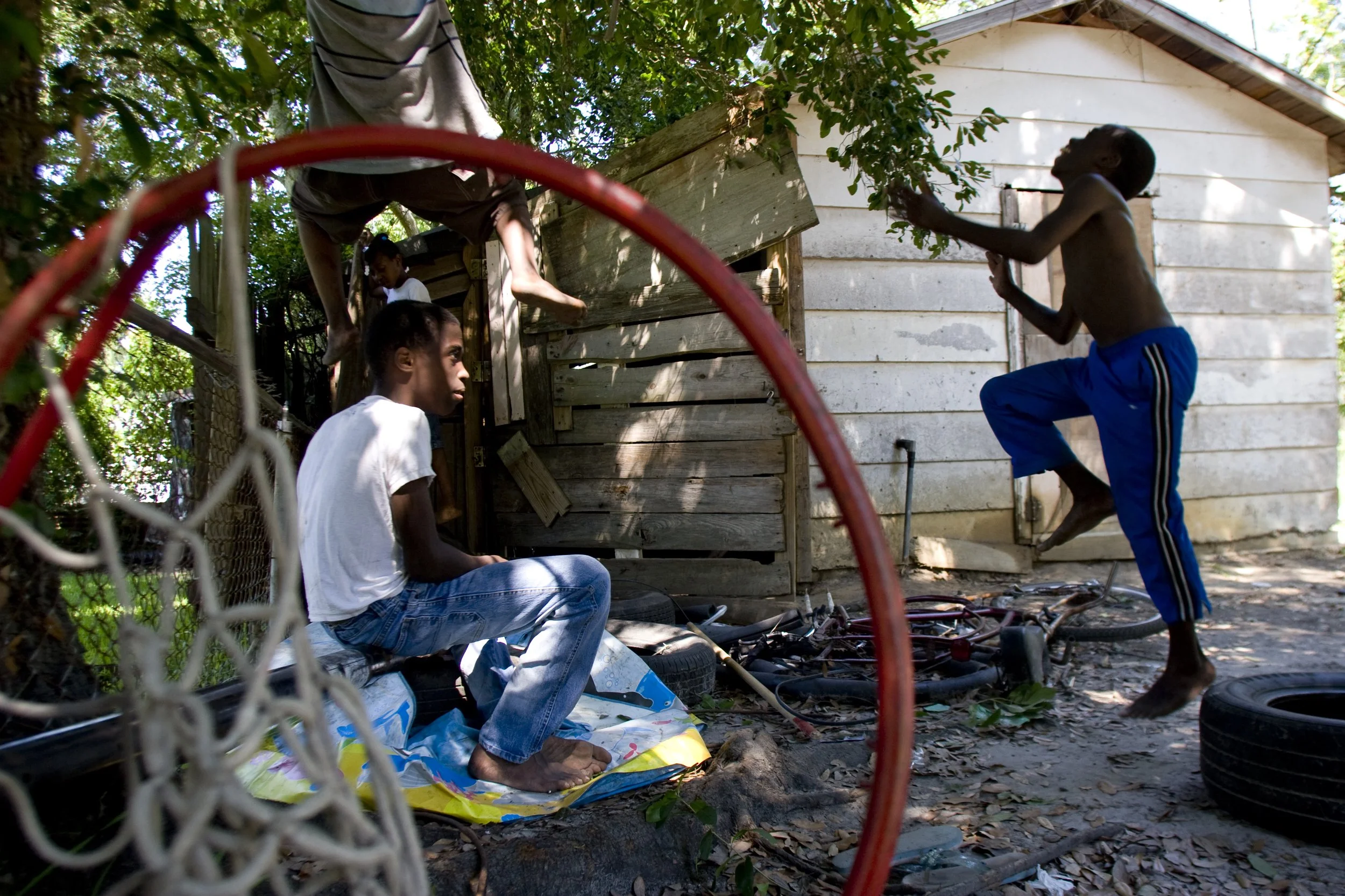 Two years after Hurricane Katrina and residents of Pascagoula, Mississippi are still living in trailers.  These brothers play behind their rotting house, in front of which is parked the trailer they are living in.