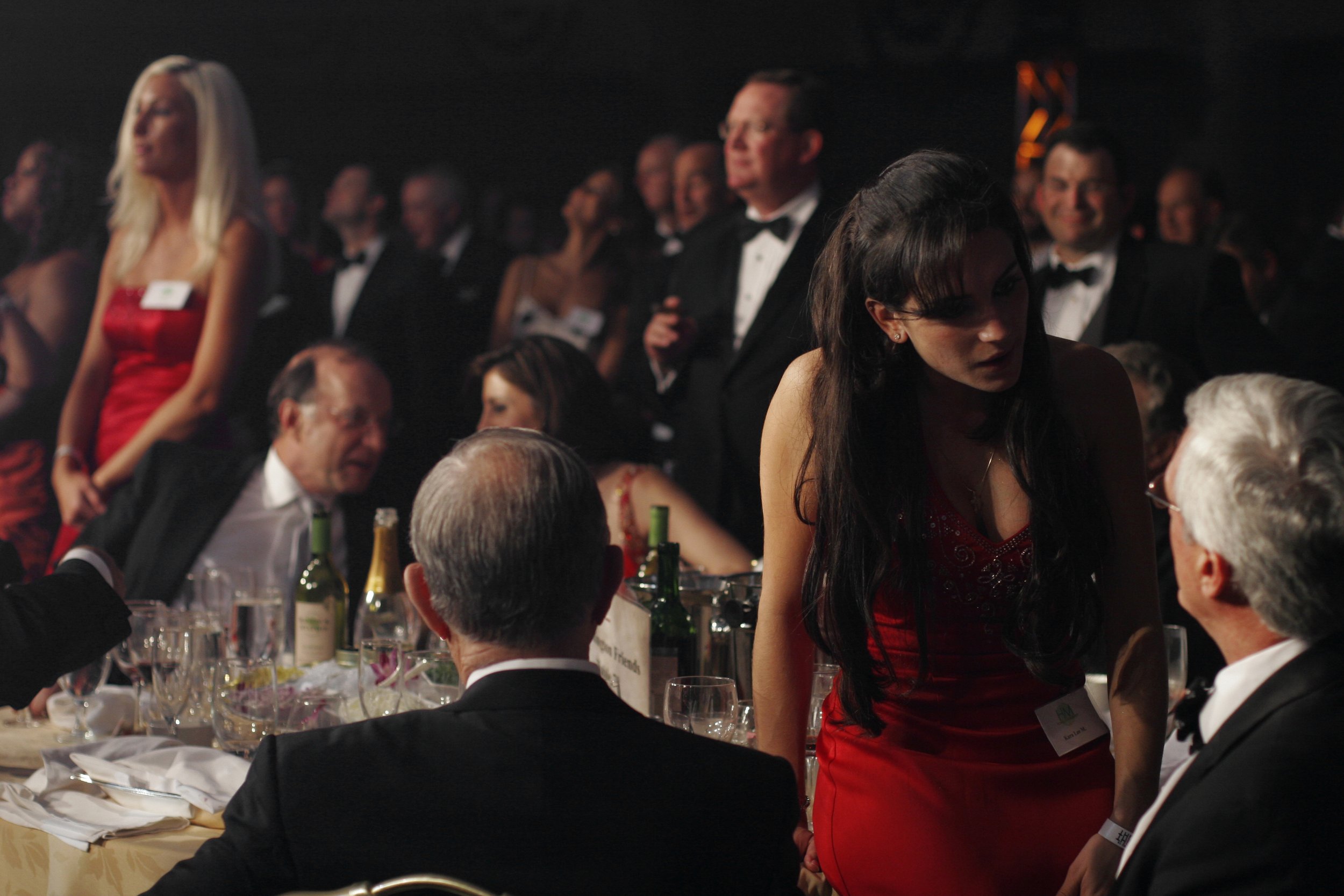 Every table at this Washington, DC fundraiser has a dedicated service representative dressed in red, hired from a modeling agency, to take care of all the doners needs. 