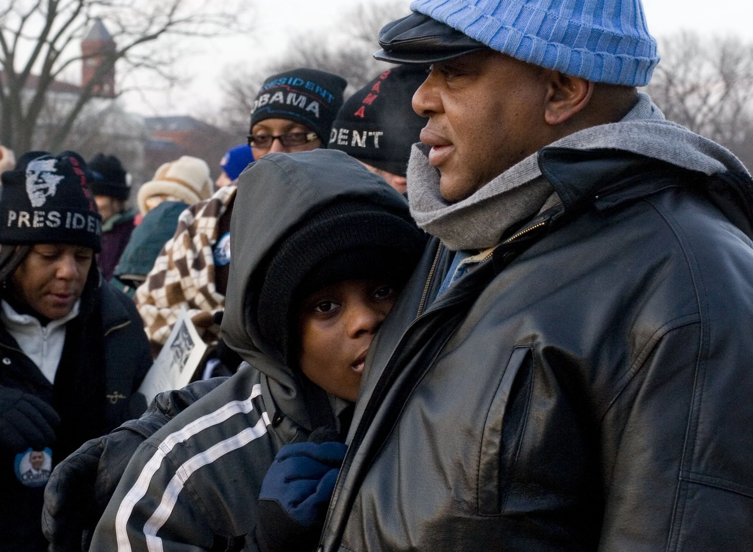 Father and son huddle in the cold after arrving early on the National Mall for President Barack Obama’s first inauguration.