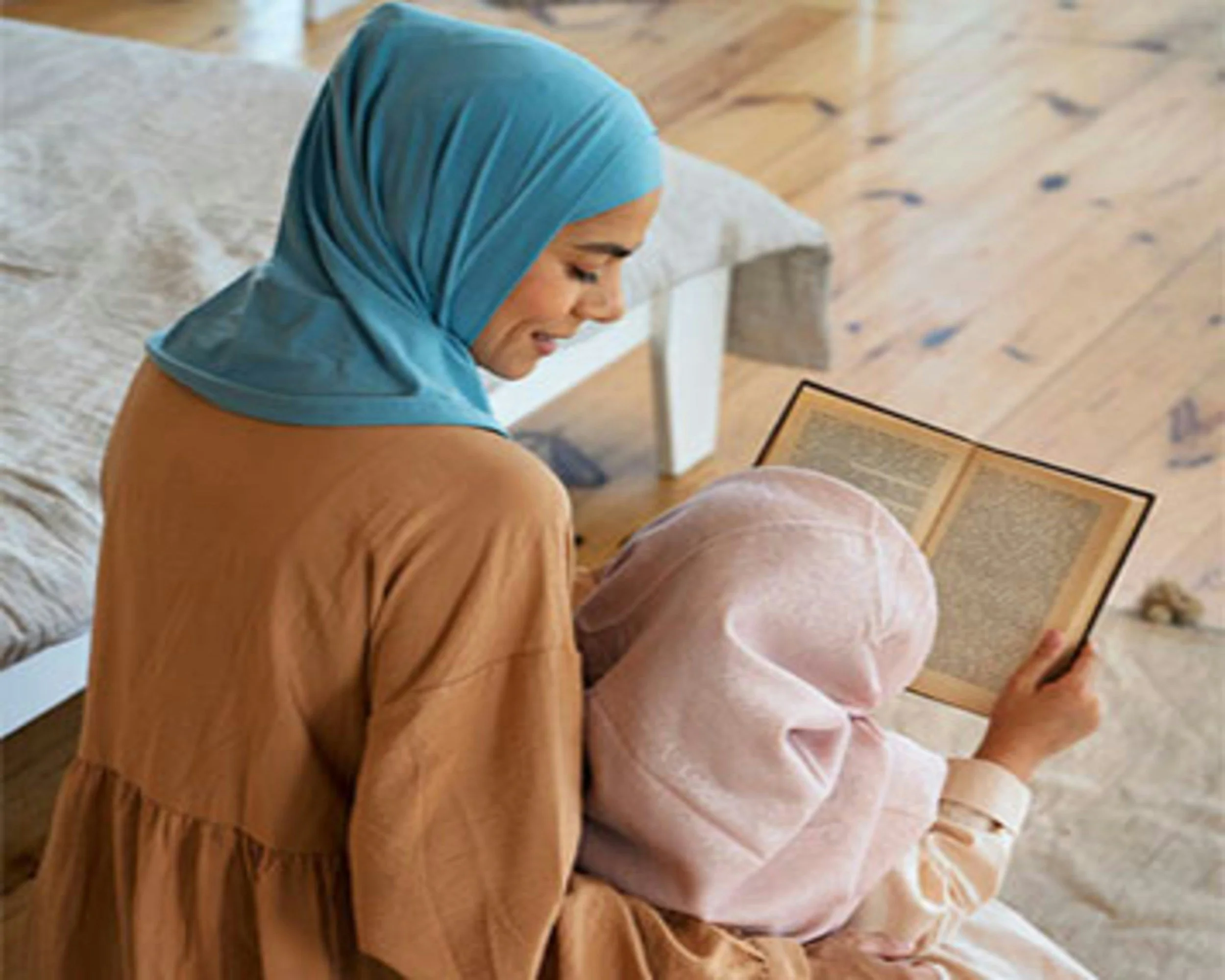 hijabi mom reading to child holding book