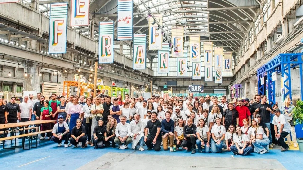 Groupe de chefs réunis dans la grande halle du Lyon Street Food Festival sous des banderoles colorées "Festin Français"