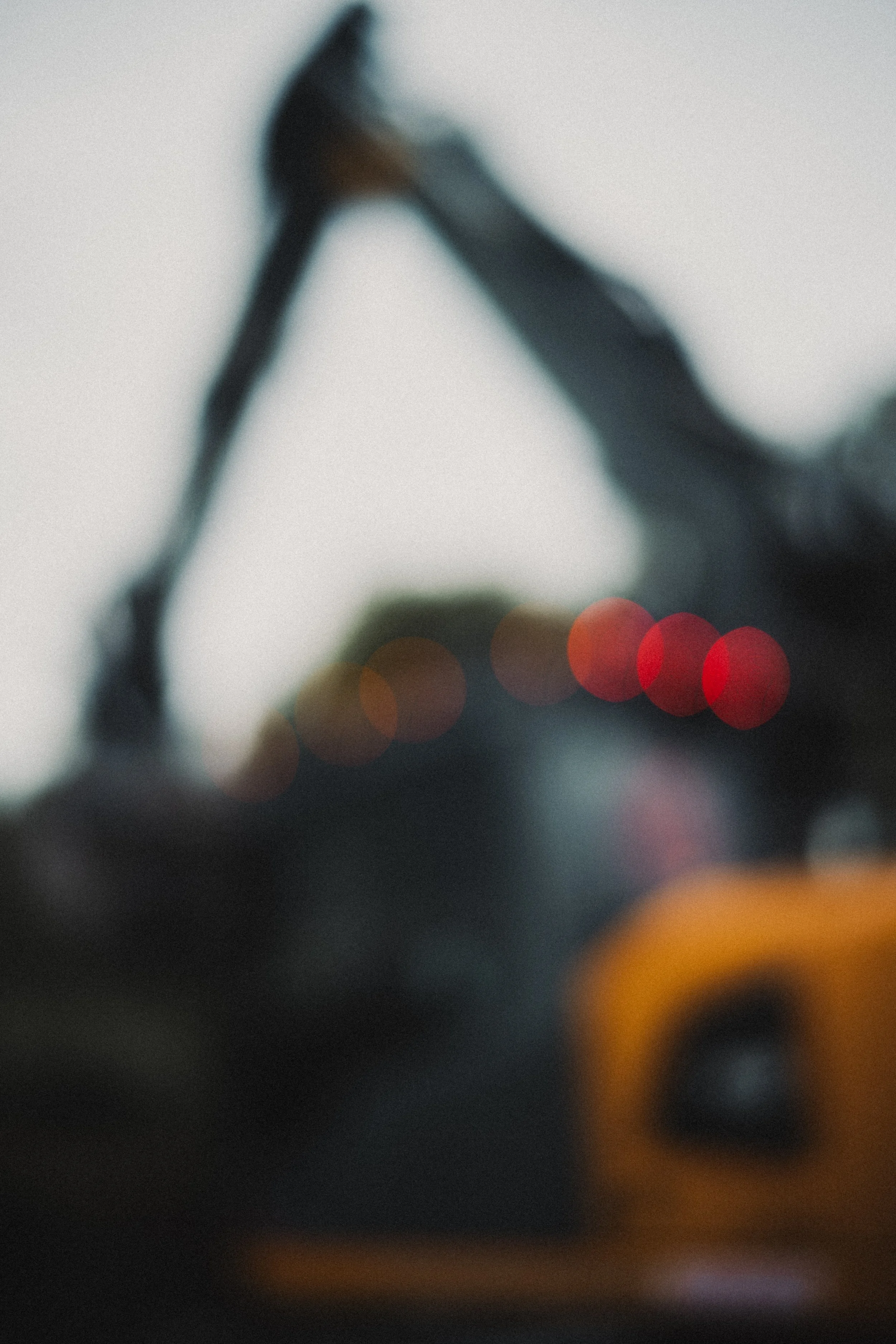 En suddig bild av en fortfarande i arbete kanalgrip, med lysande röda och orangea lampor i bakgrunden.