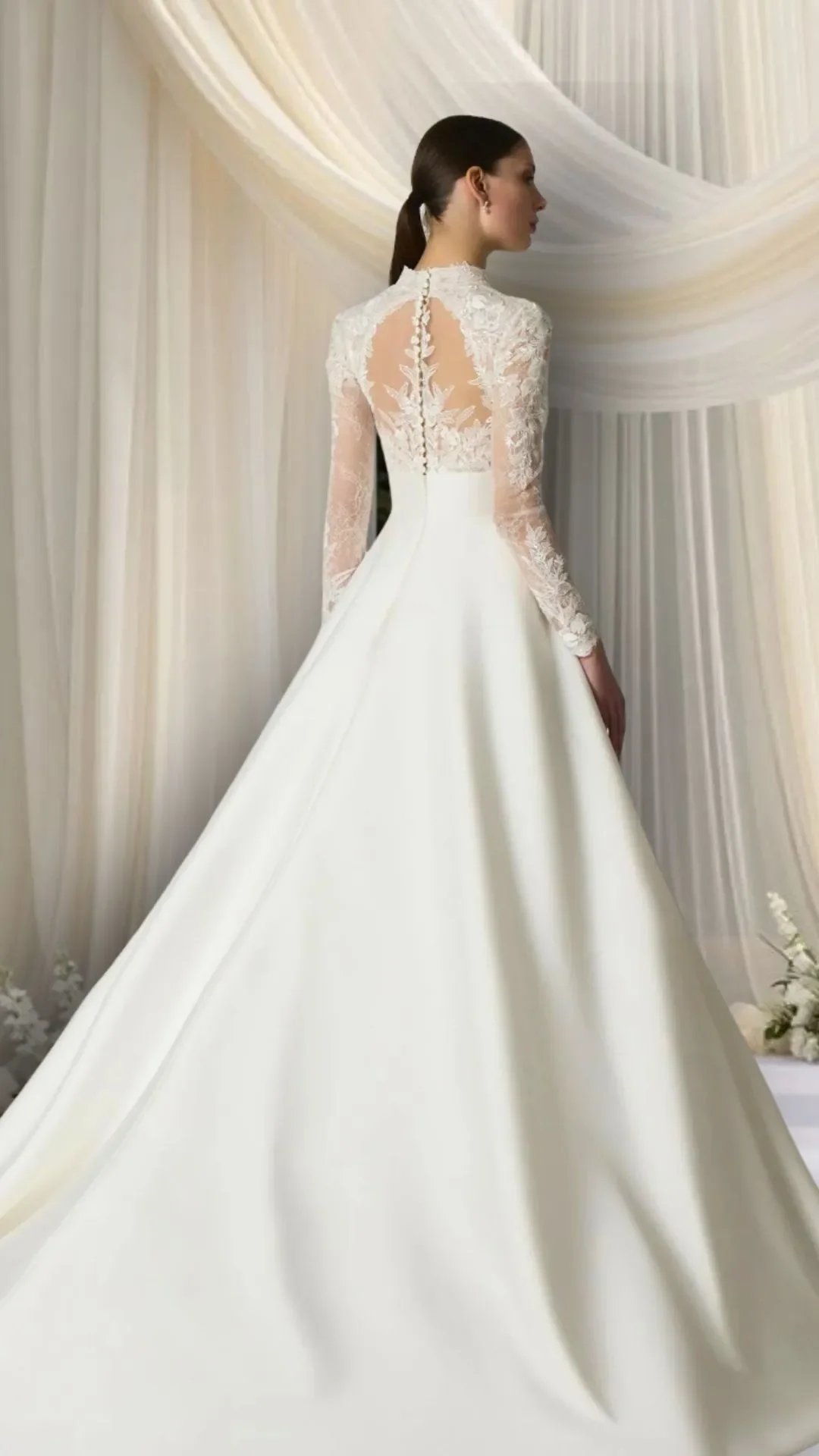 Mulher usando vestido de noiva com saia longa e bodice de renda com mangas longas.