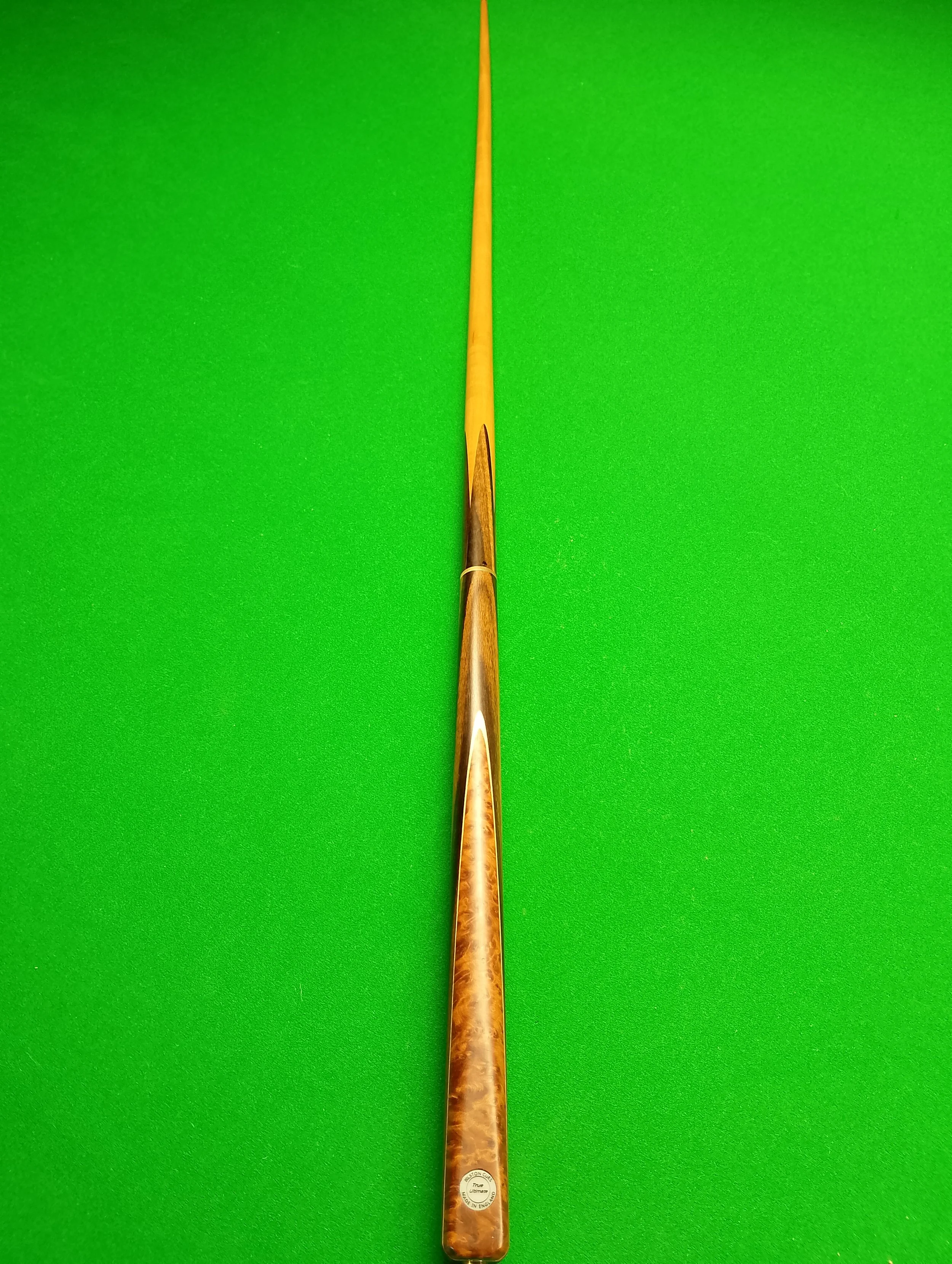 Snooker cue stick on a green snooker table.