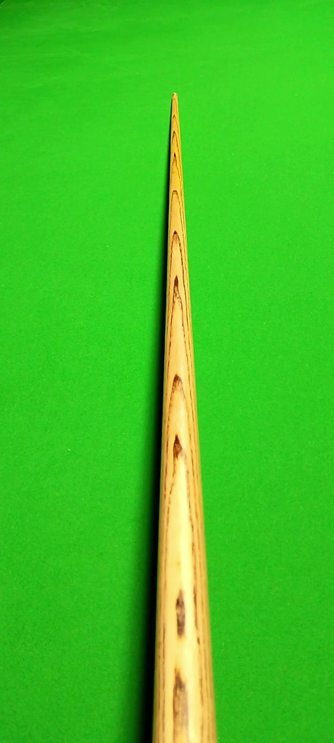 Close-up of a wooden skewer on a green background.