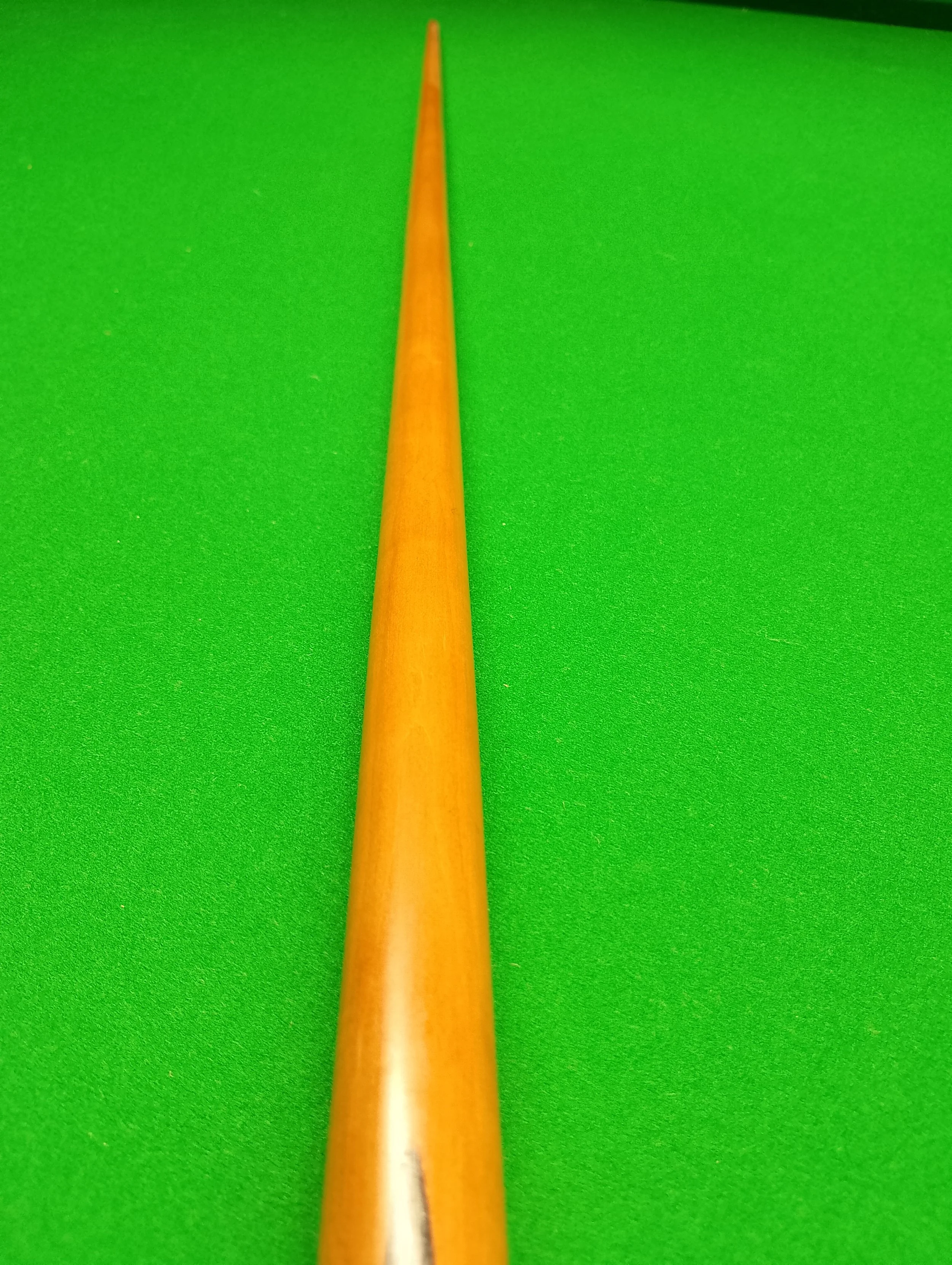 View of a cue stick on a green pool table