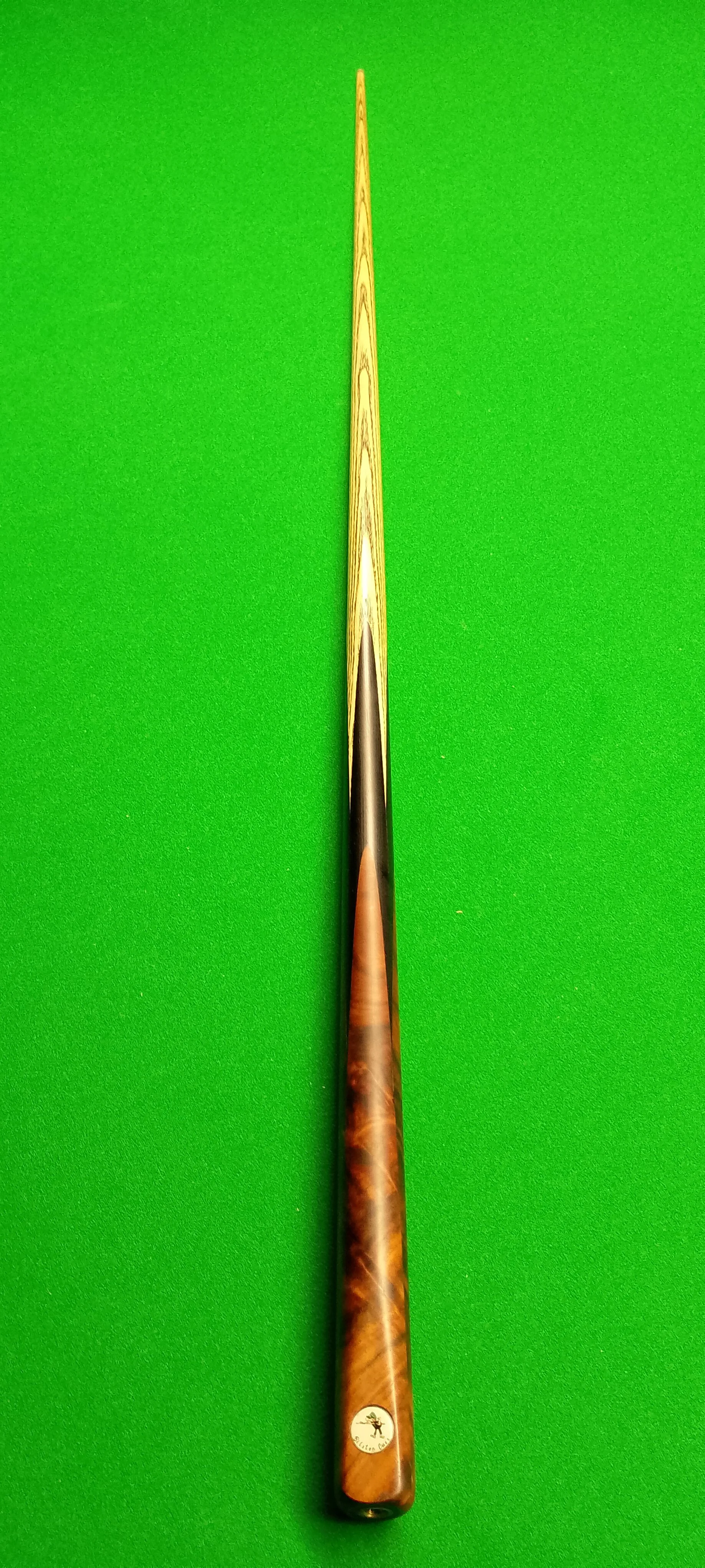 A cue stick resting on a green pool table felt.