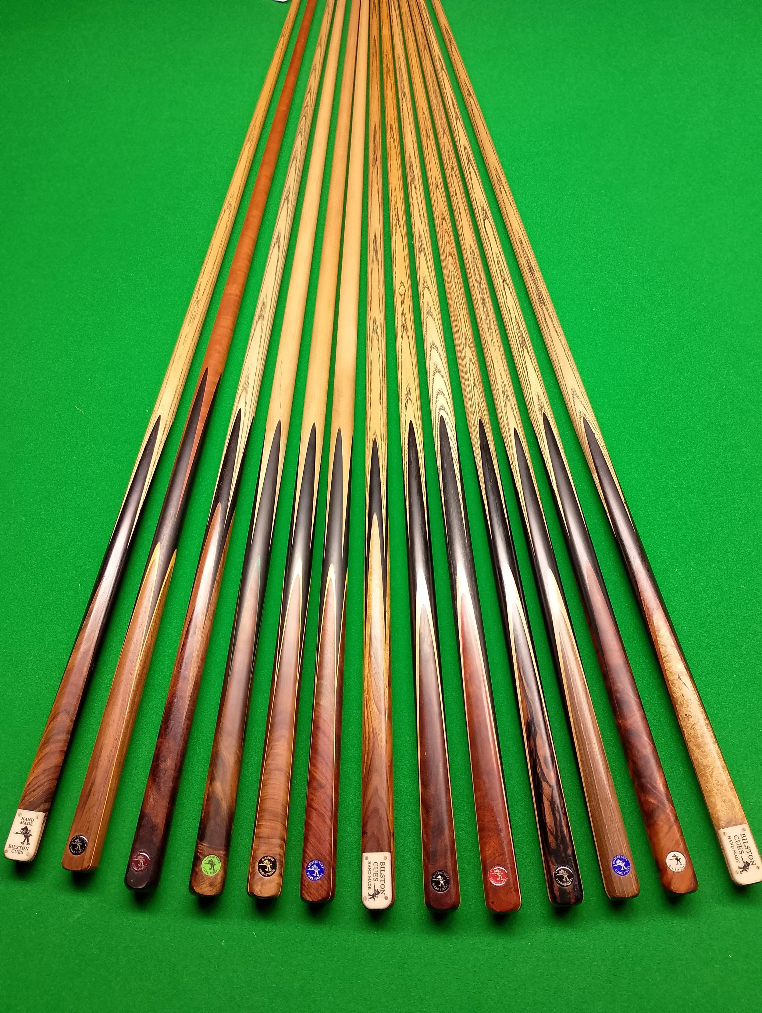 Set of cue sticks arranged on a green pool table.