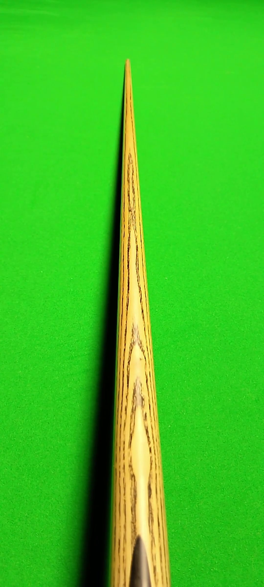Close-up of tennis racket stringer, showing the wooden frame and stringing area against a bright green background.