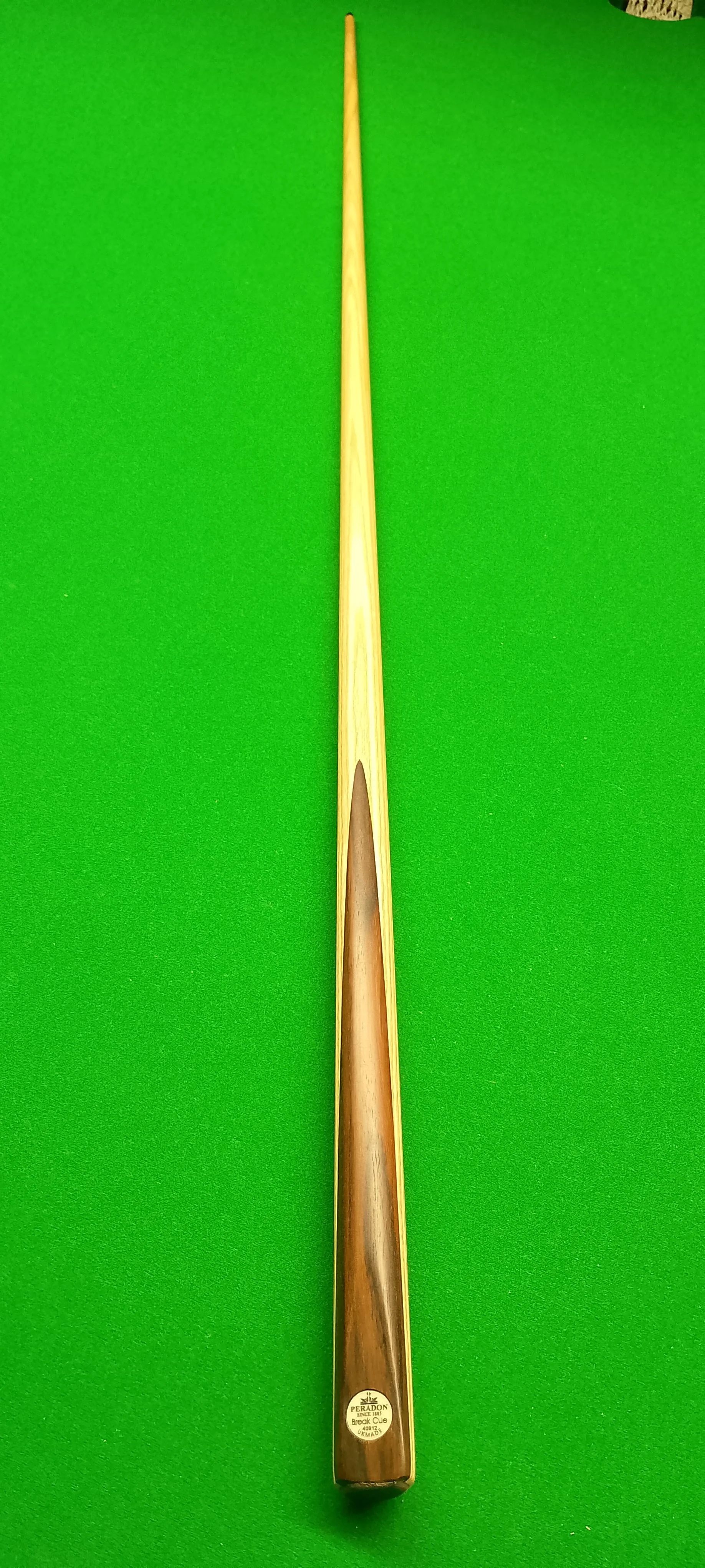 A snooker cue stick on a green felt table.