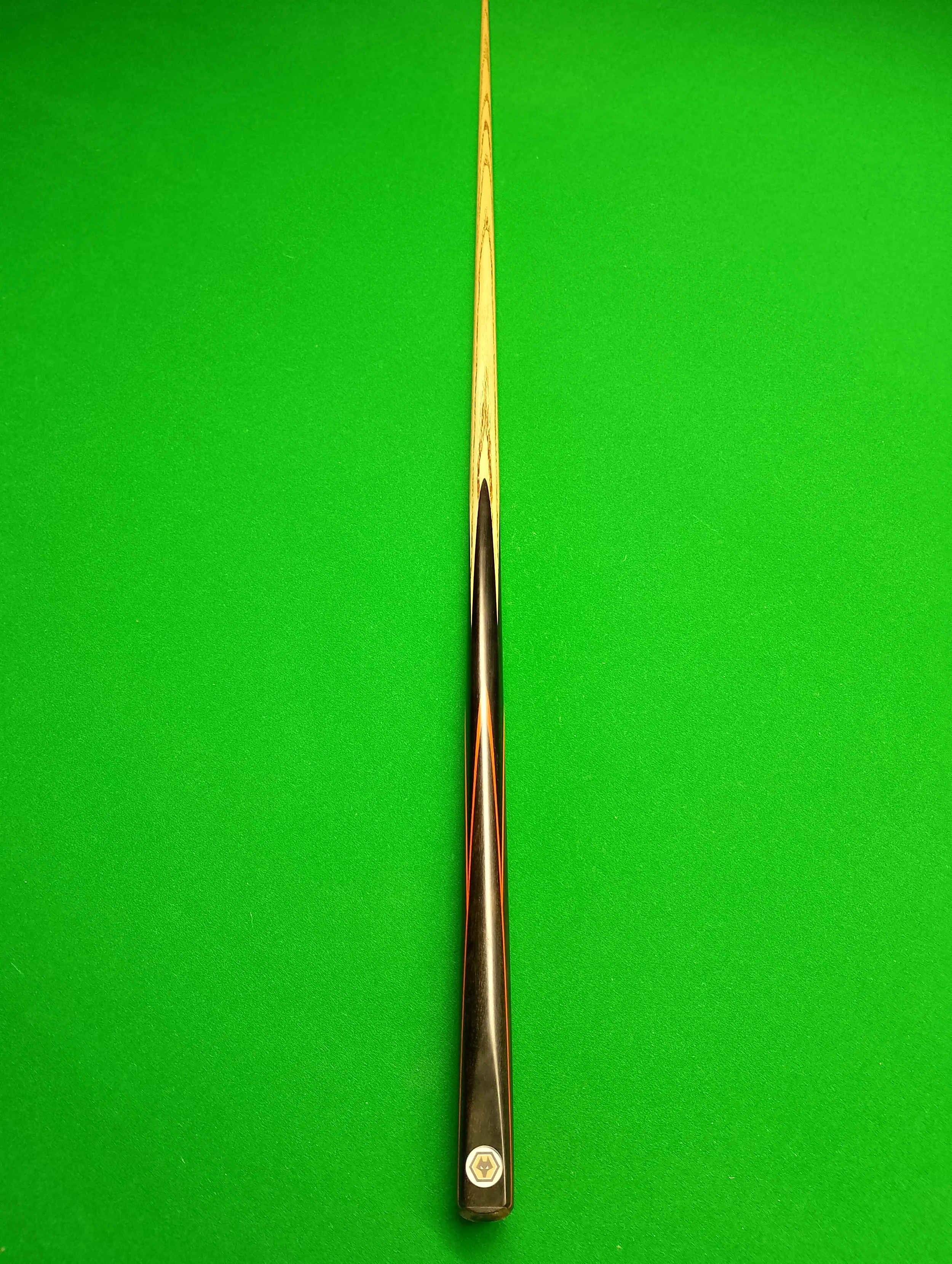 A pool cue stick on a green pool table.