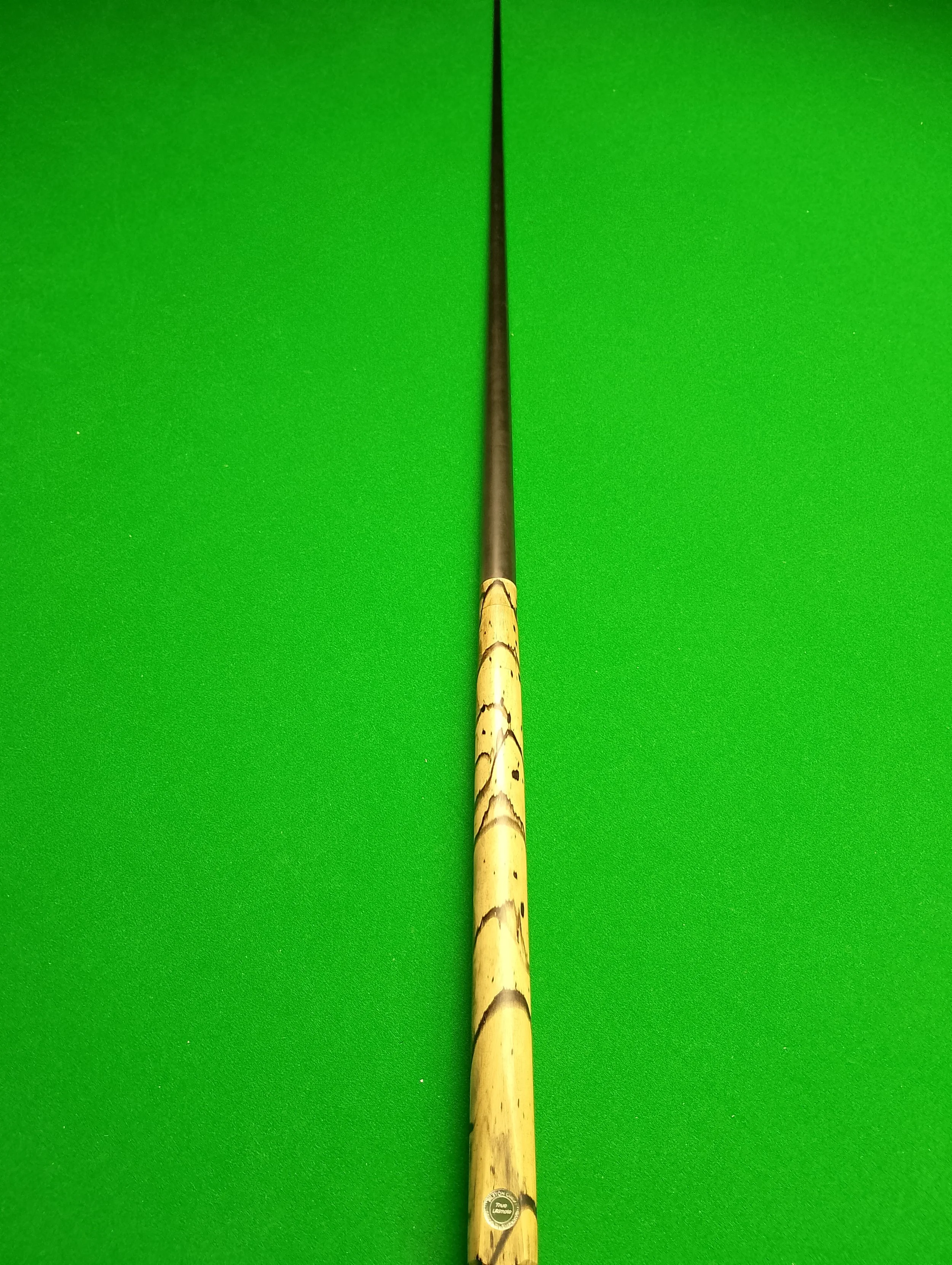 Pool cue stick on a green felt billiard table.