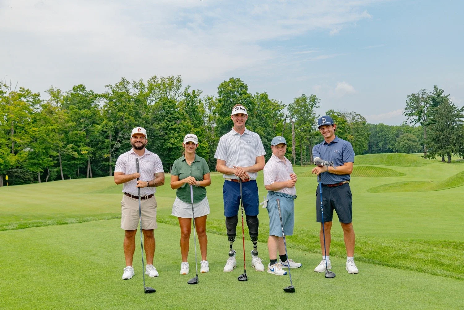 Five adaptive golfers smiling at the camera.