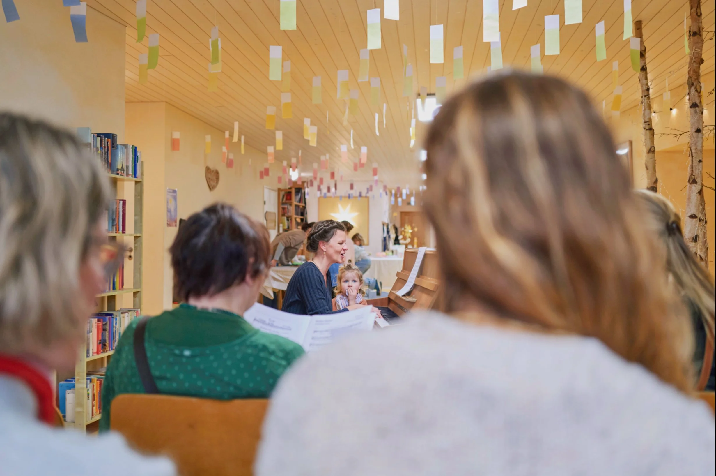 Kinder und Erwachsene beim traditionellen Kerzenziehen in der Adventszeit im Schulhaus
