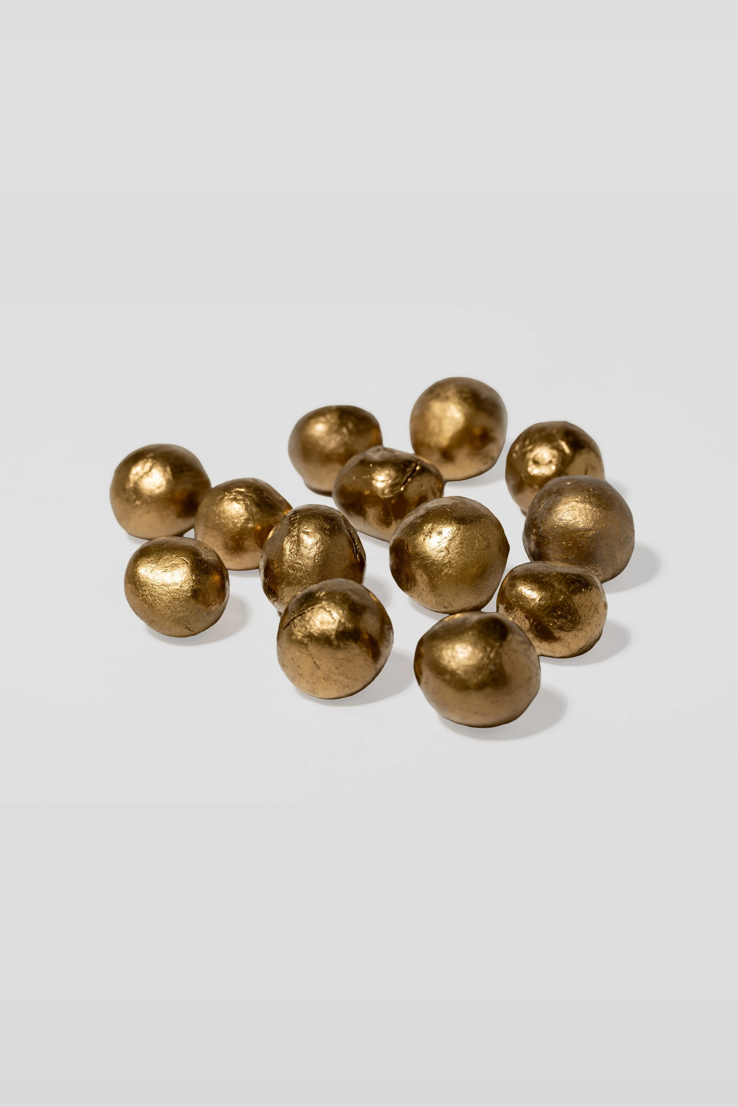 Zwergengold aus Ton und Dekogold mit Edelsteinen drinnen versteckt., liegen auf einem weißen Hintergrund.