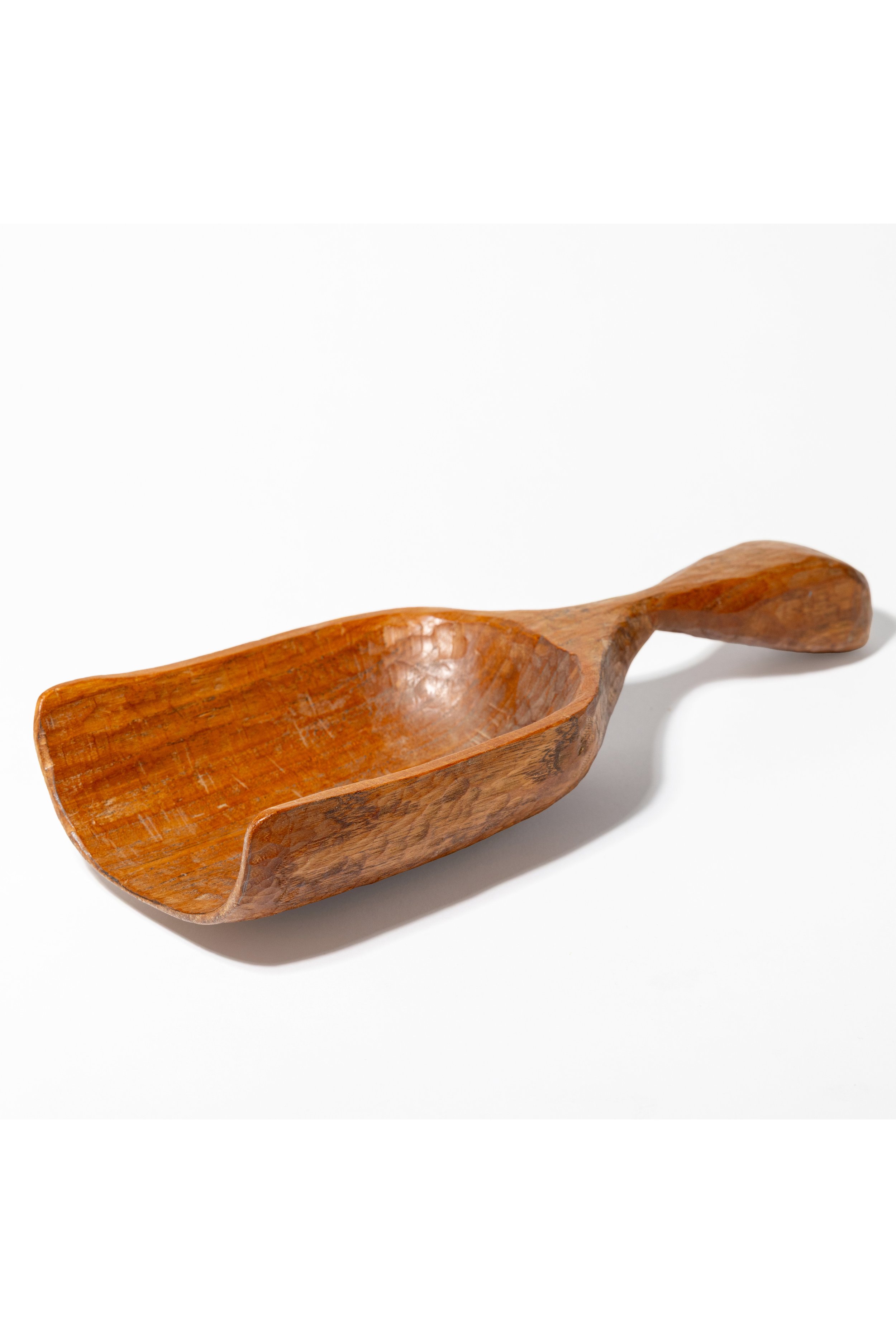 Eine handgefertigte Holzschaufel mit gebogenem Griff auf weißem Hintergrund.