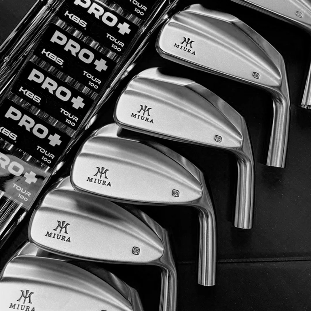A set of Miura golf club irons arranged in a row. Custom fitted by Tour Truck Golf "HBS TOUR 100."