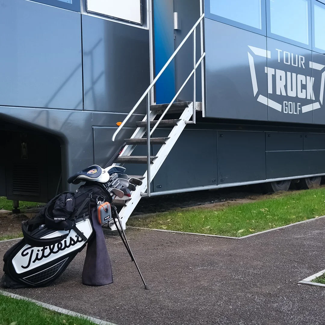 A person is adjusting a golf club with a tool in their hand at a golf course.