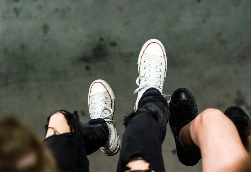Young people walking across the pavement.