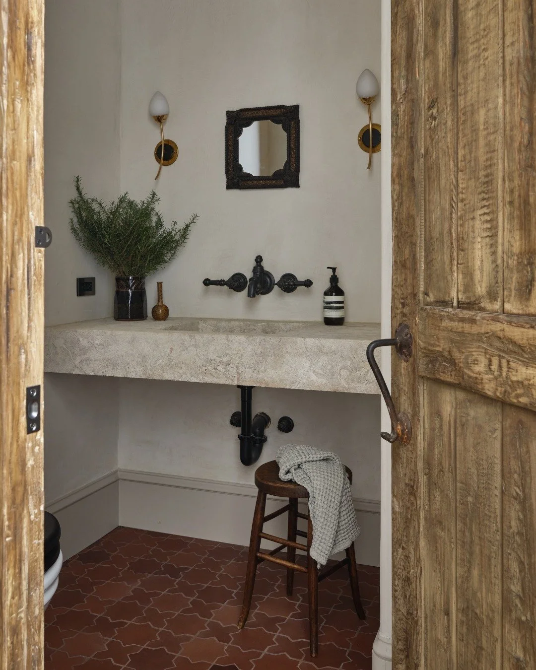 A powder room filled with the most charming details.

Swipe for behind the scenes look in to the design process featuring a reproduction antique stone sink, plaster walls, terracotta floors and vintage sconces.

📸 @michaelcliffordphotography
Constru