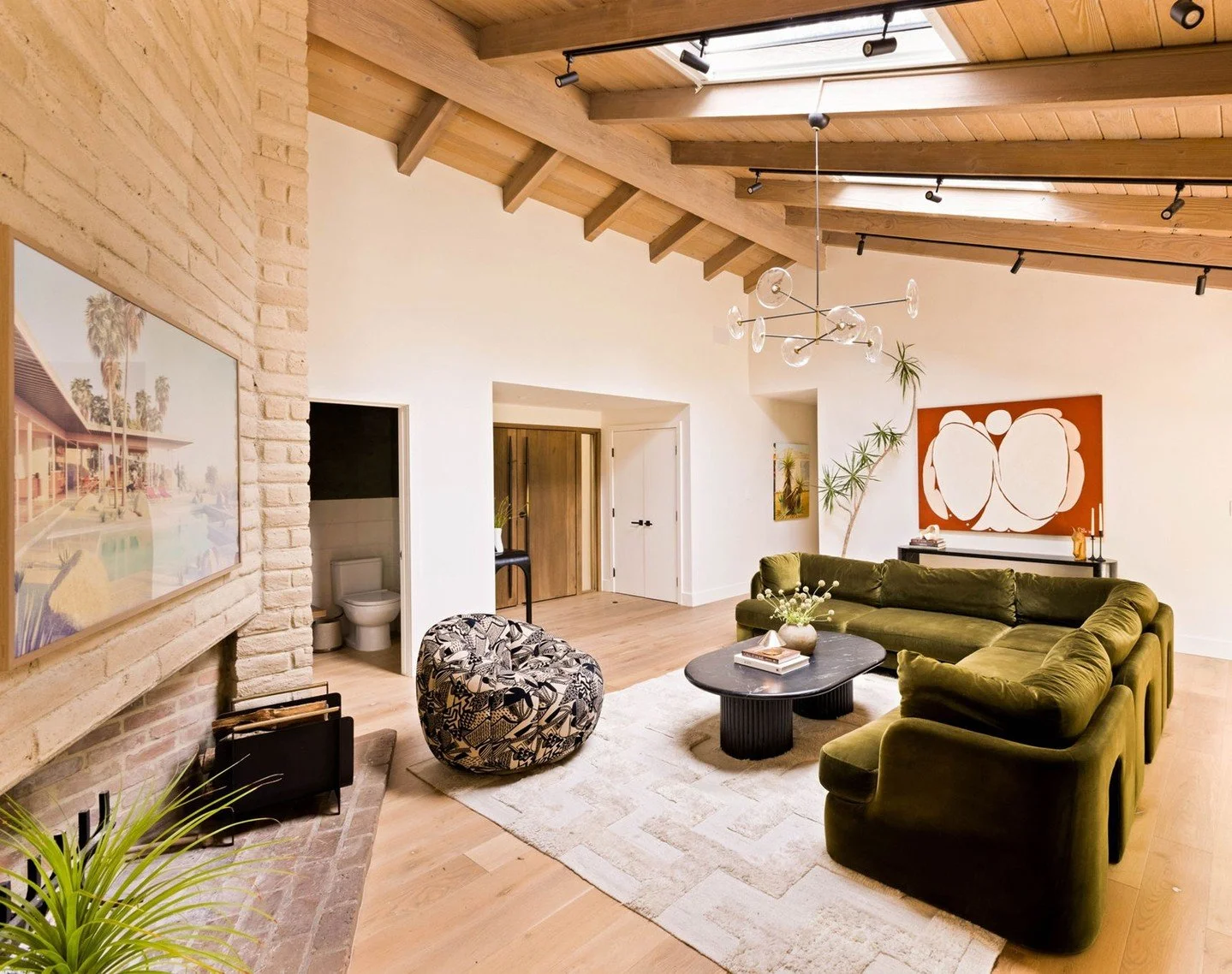 A peak into the family room of our Canyon Ranch house. Here, we preserved the homes original architectural details, like exposed wood ceiling and brick fireplace, while enhancing the overall floor plan of the home.

#midcentury #ranchhouse #modernint