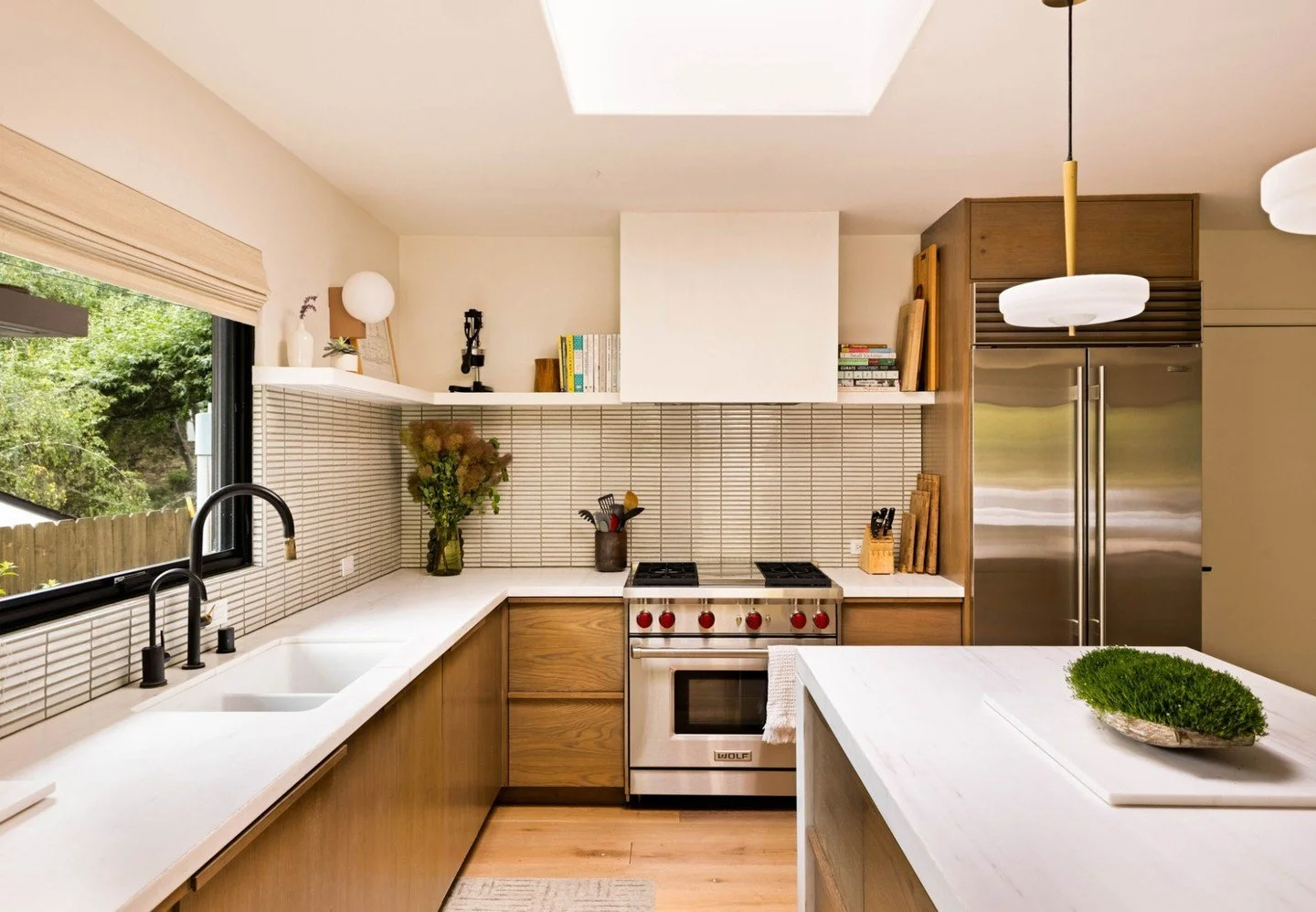 A major transformation of the kitchen in our mid-century Canyon Ranch home. We opened up the kitchen and refreshed the space with plastered walls, a new island, bespoke cabinetry, updated lighting, and a modern stacked tile layout&mdash;bringing a cl